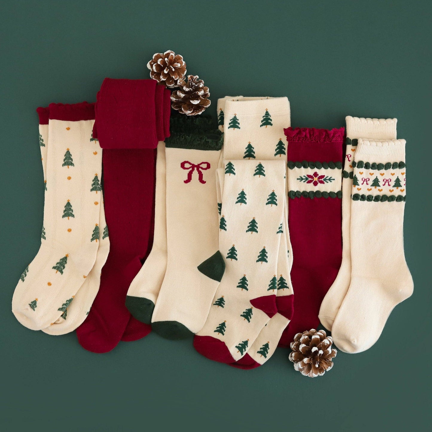 Set of Christmas-themed socks with tree patterns and red accents on a green background