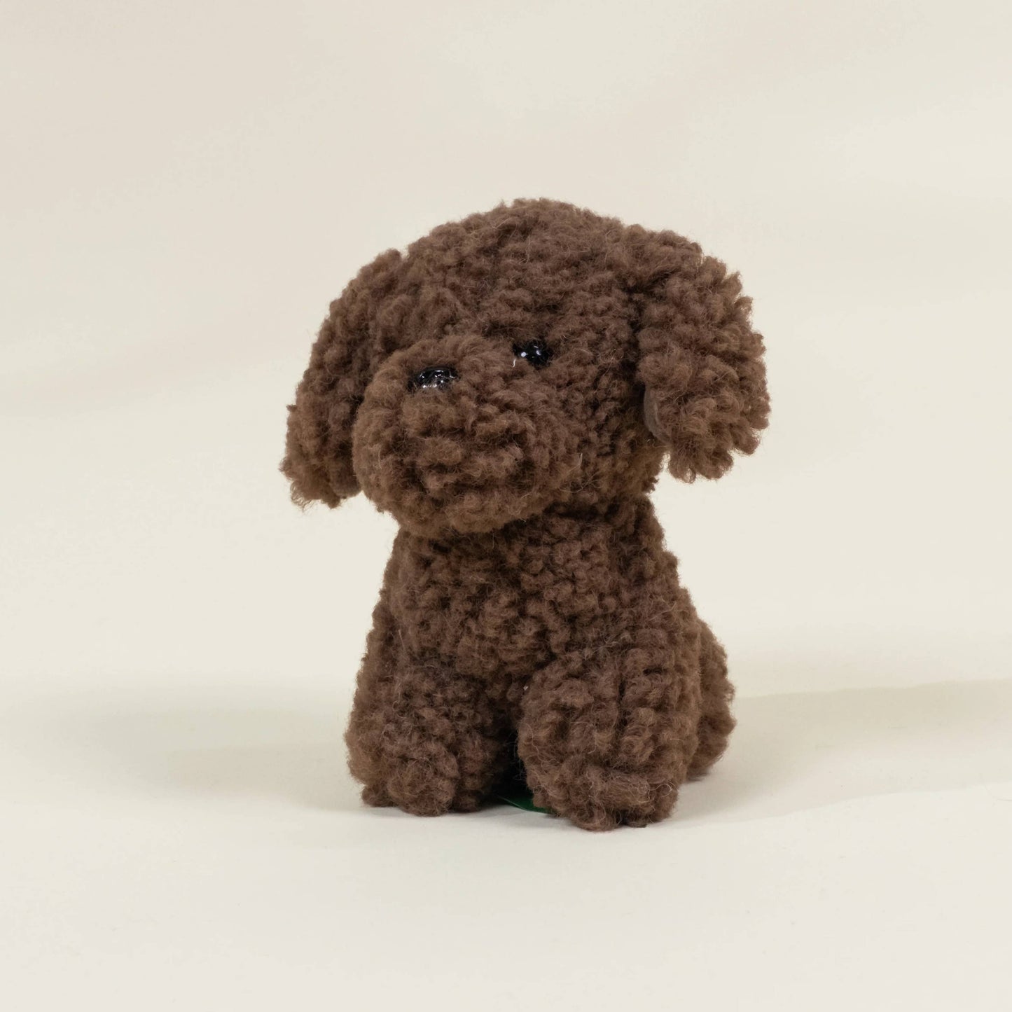 Brown plush dog toy on a beige background