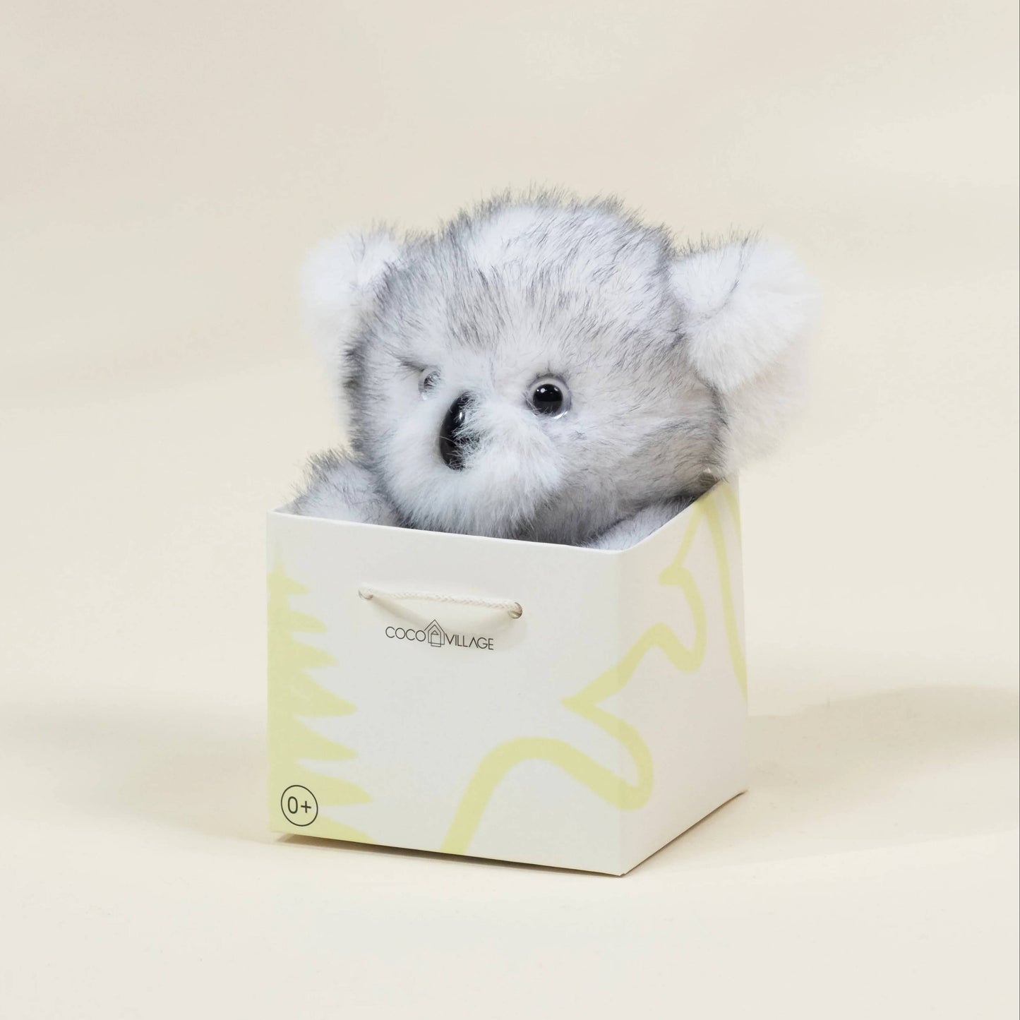 Plush bear toy in a decorative box on a light background