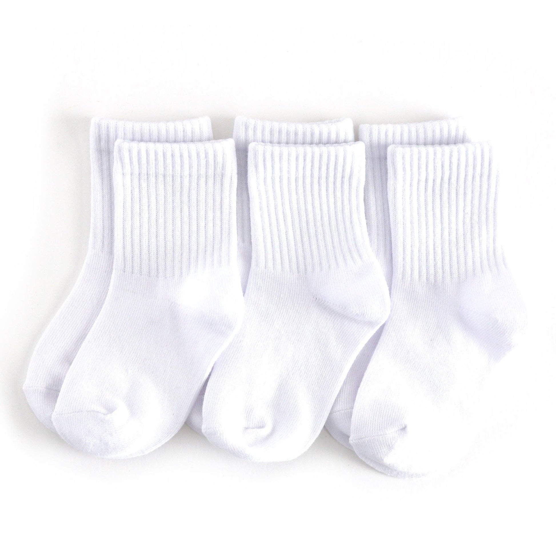 Three pairs of white socks on a light gray background