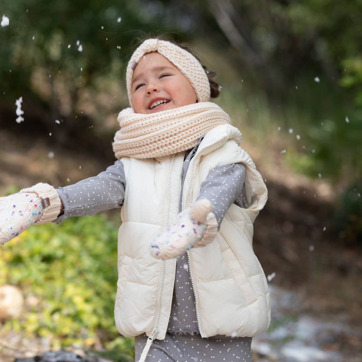 Child in winter clothing playing in the snow