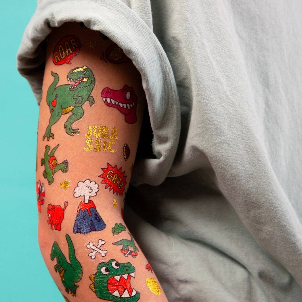 Colorful temporary tattoos on a person's arm against a light blue background