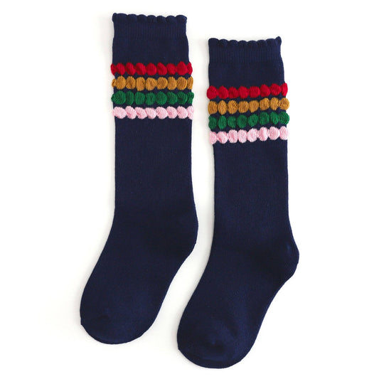 Navy blue socks with colorful pom-pom details on a white background