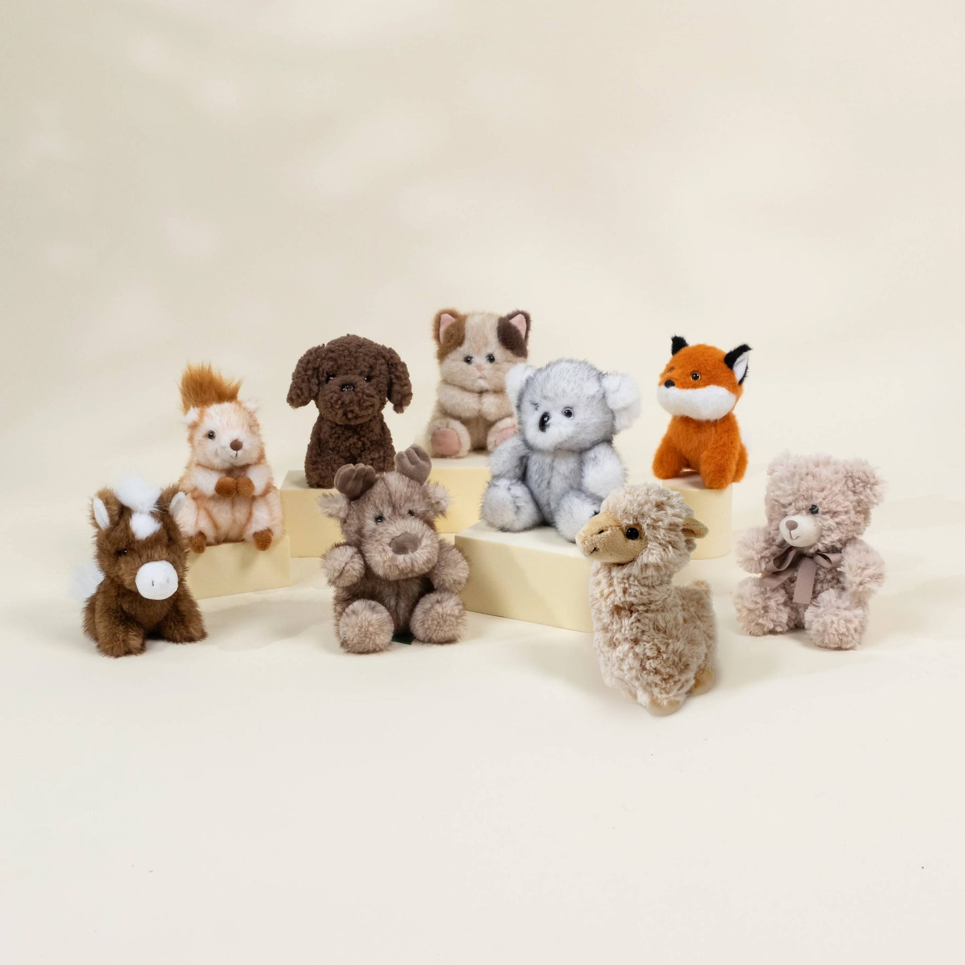 Collection of small stuffed animals on a beige background