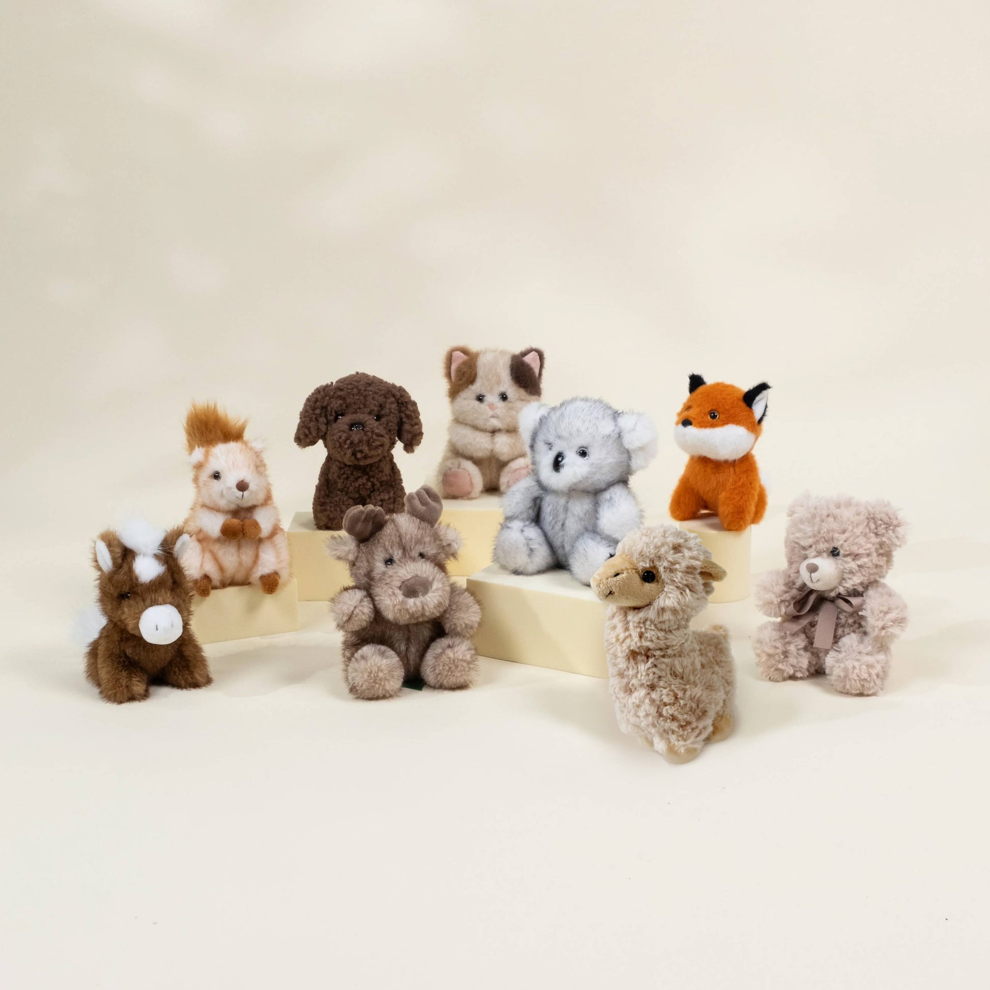 Collection of small stuffed animals on a beige background
