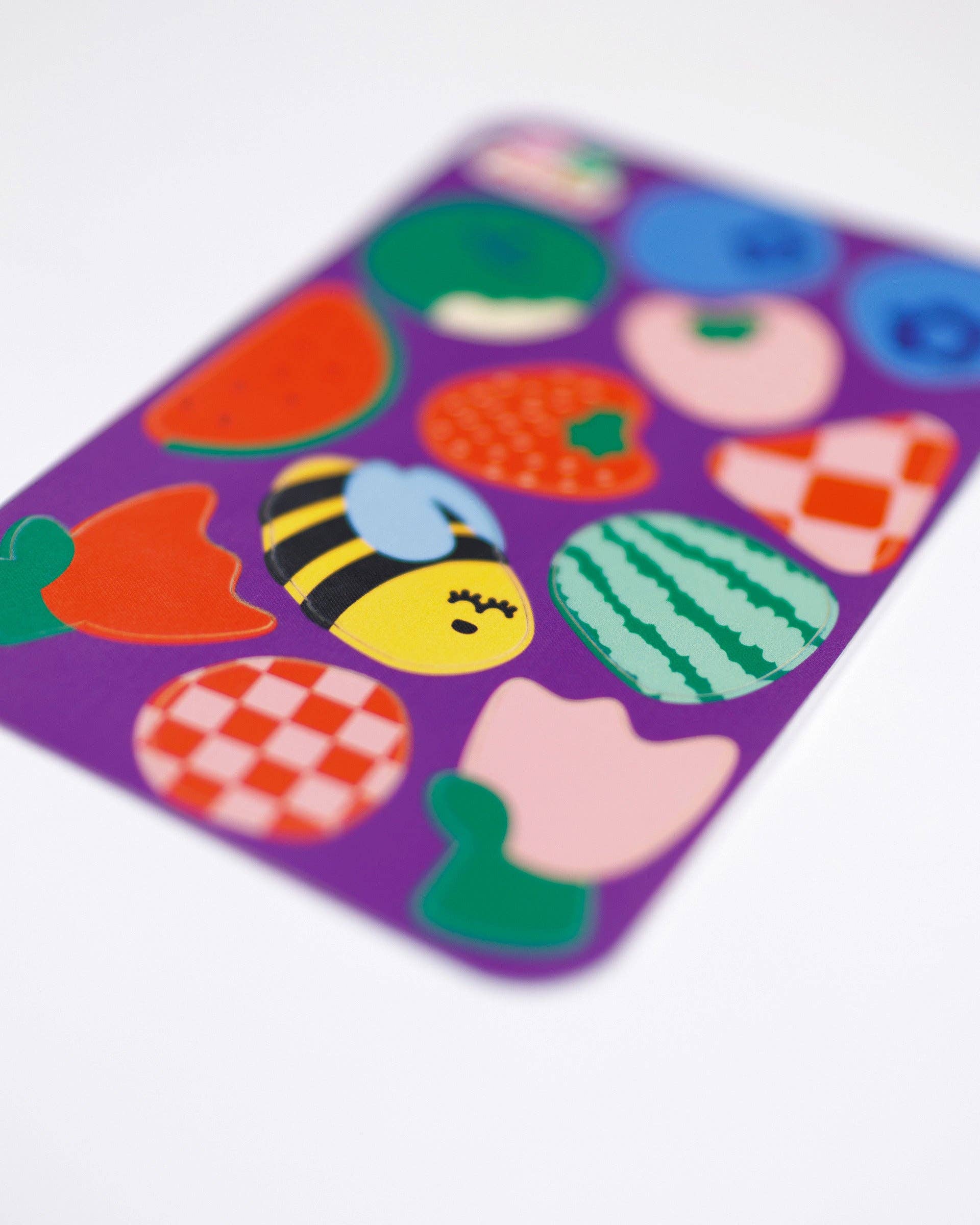 Colorful children's sticker patches on a purple backing with a white background