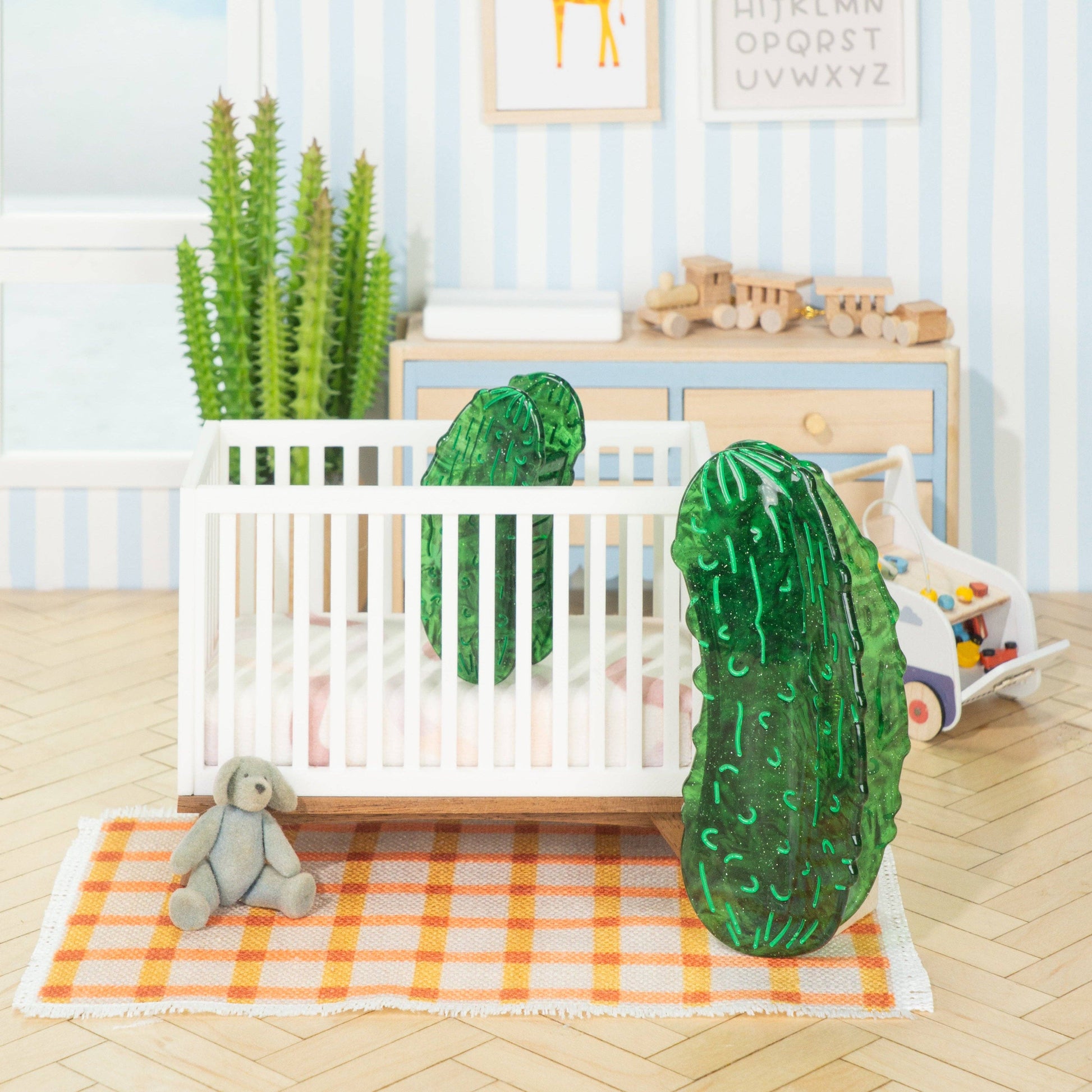 Nursery room with crib, toys, and decorative elements on a light blue striped wall.