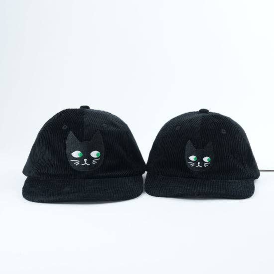 Two black caps with cat face designs on a white background