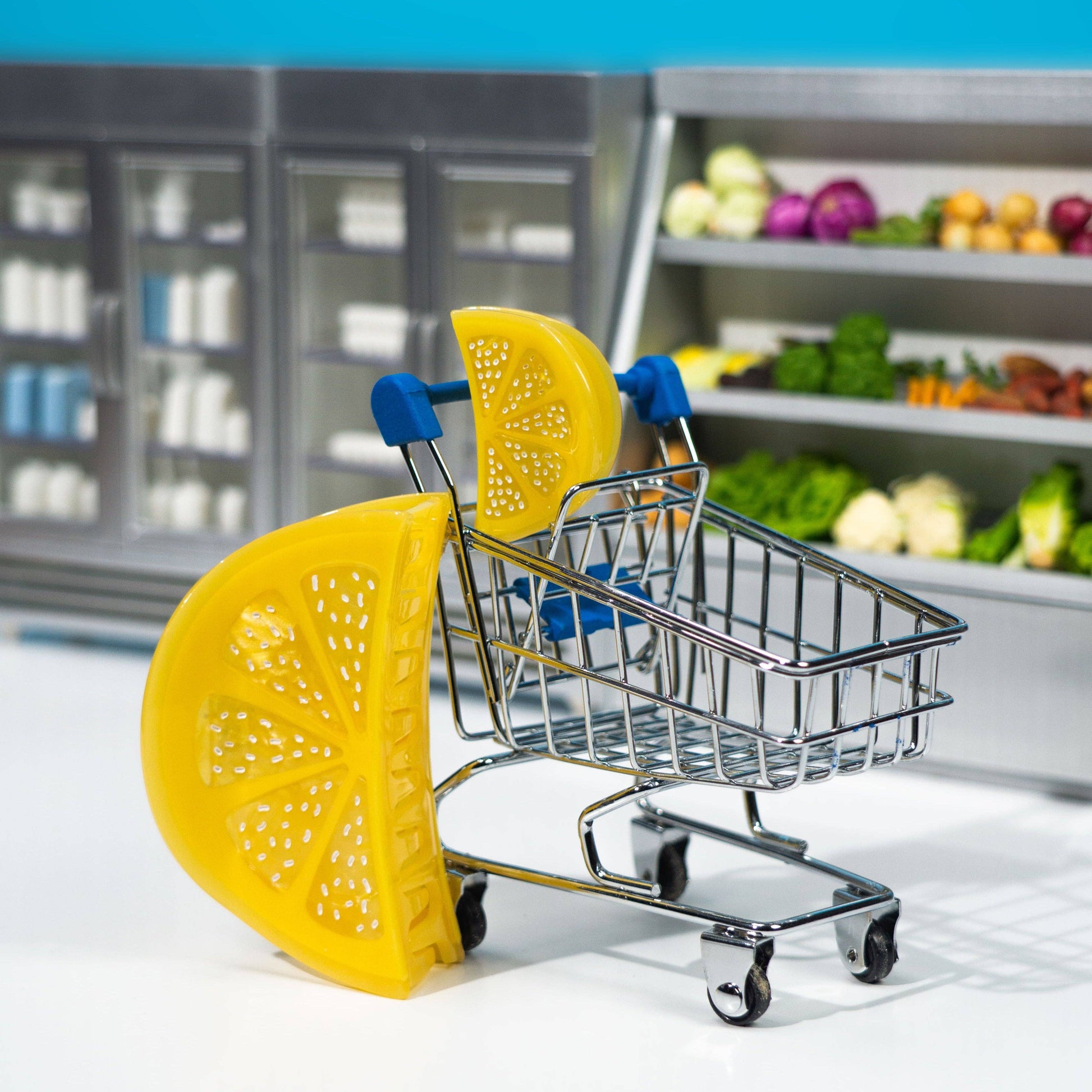 Miniature shopping cart with lemon slices in a grocery store setting