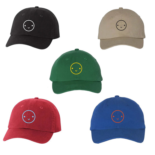 Five baseball caps in black, beige, green, red, and blue with smiley face designs on a white background.