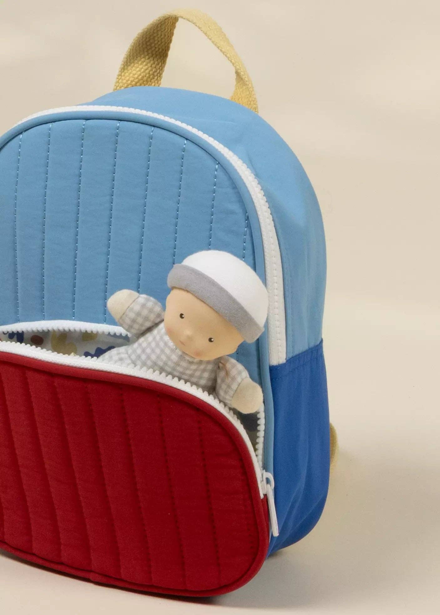 Children's backpack with a toy inside on a beige background