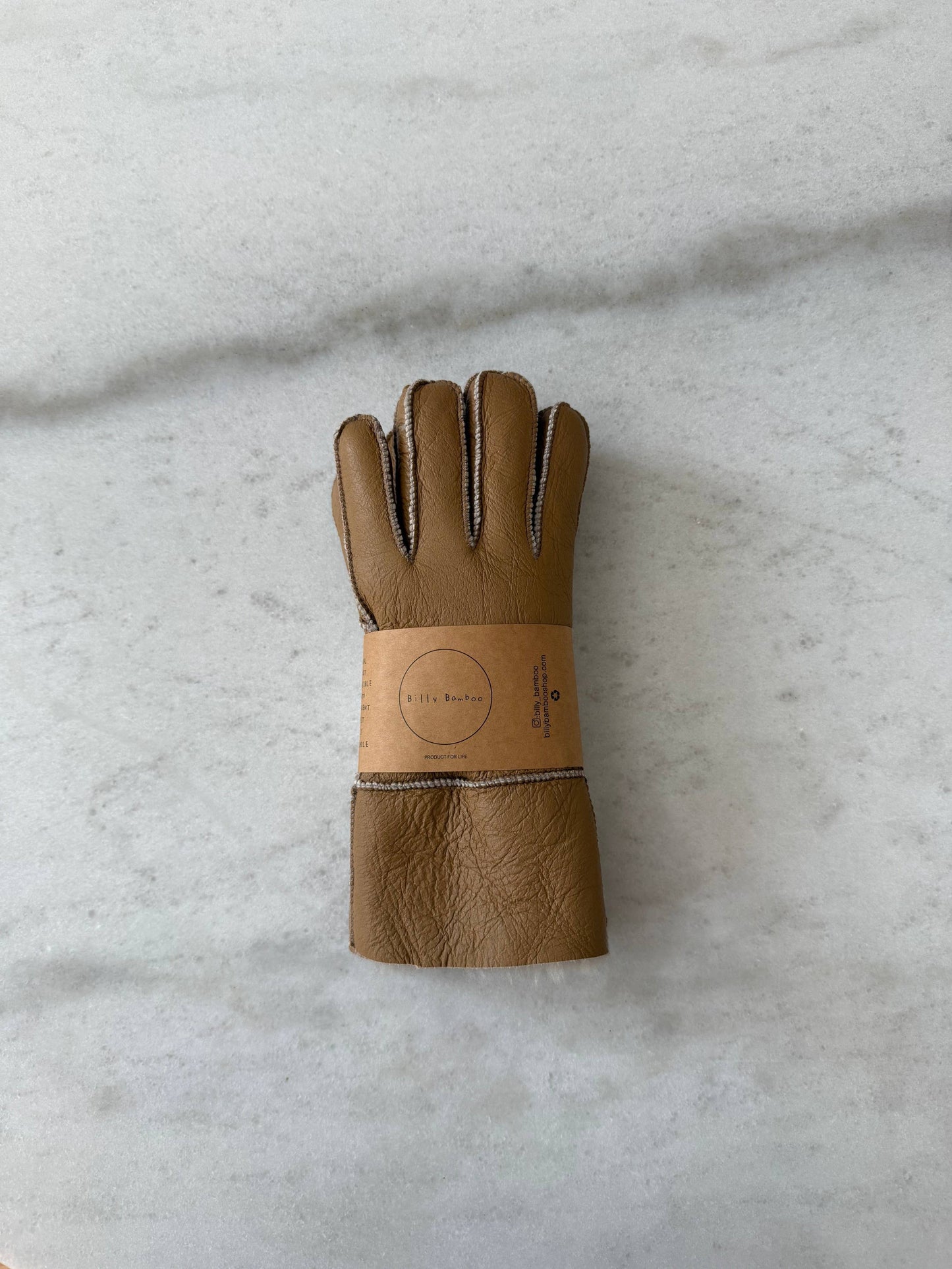 Brown leather glove on a light gray background