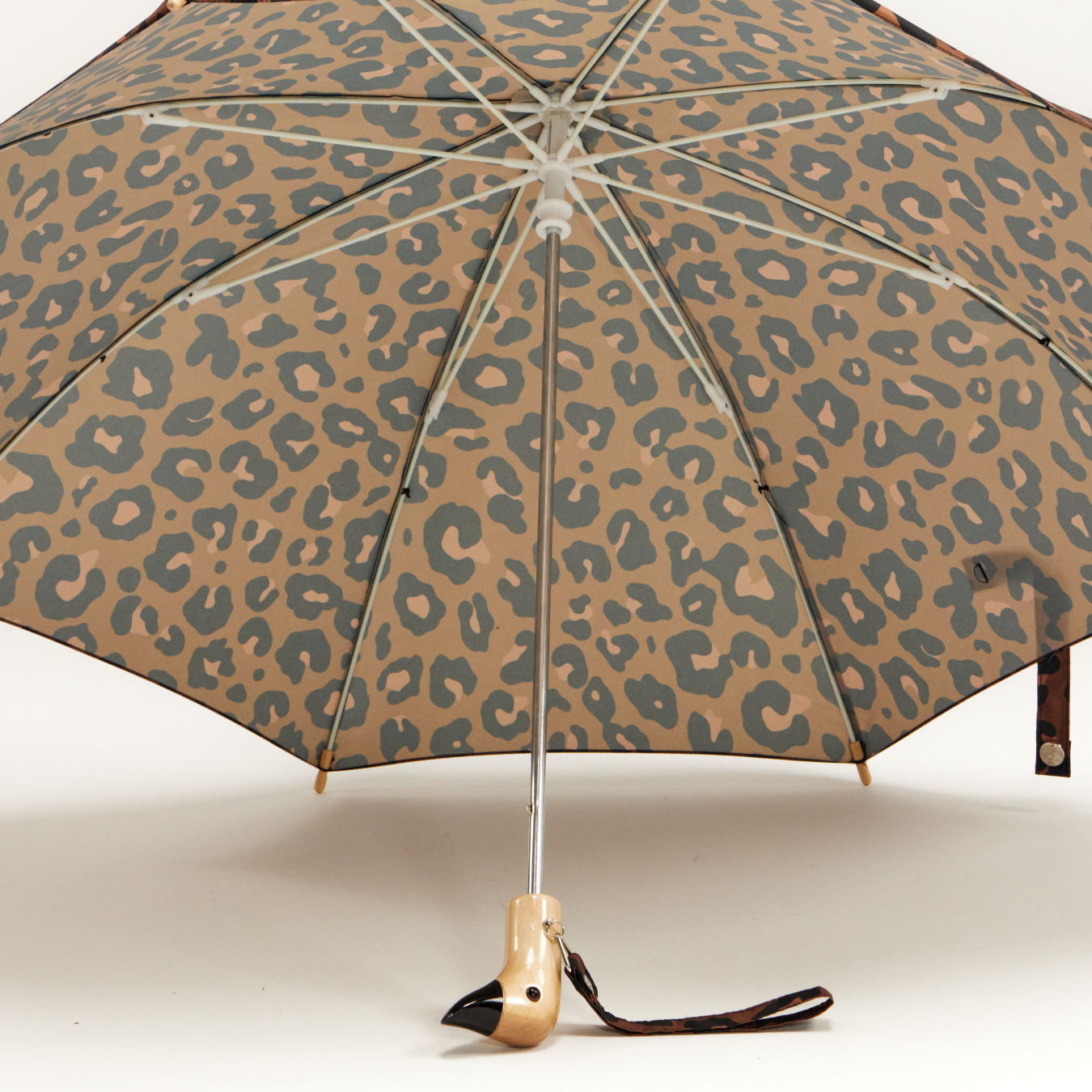 Leopard print umbrella with a gold handle on a white background