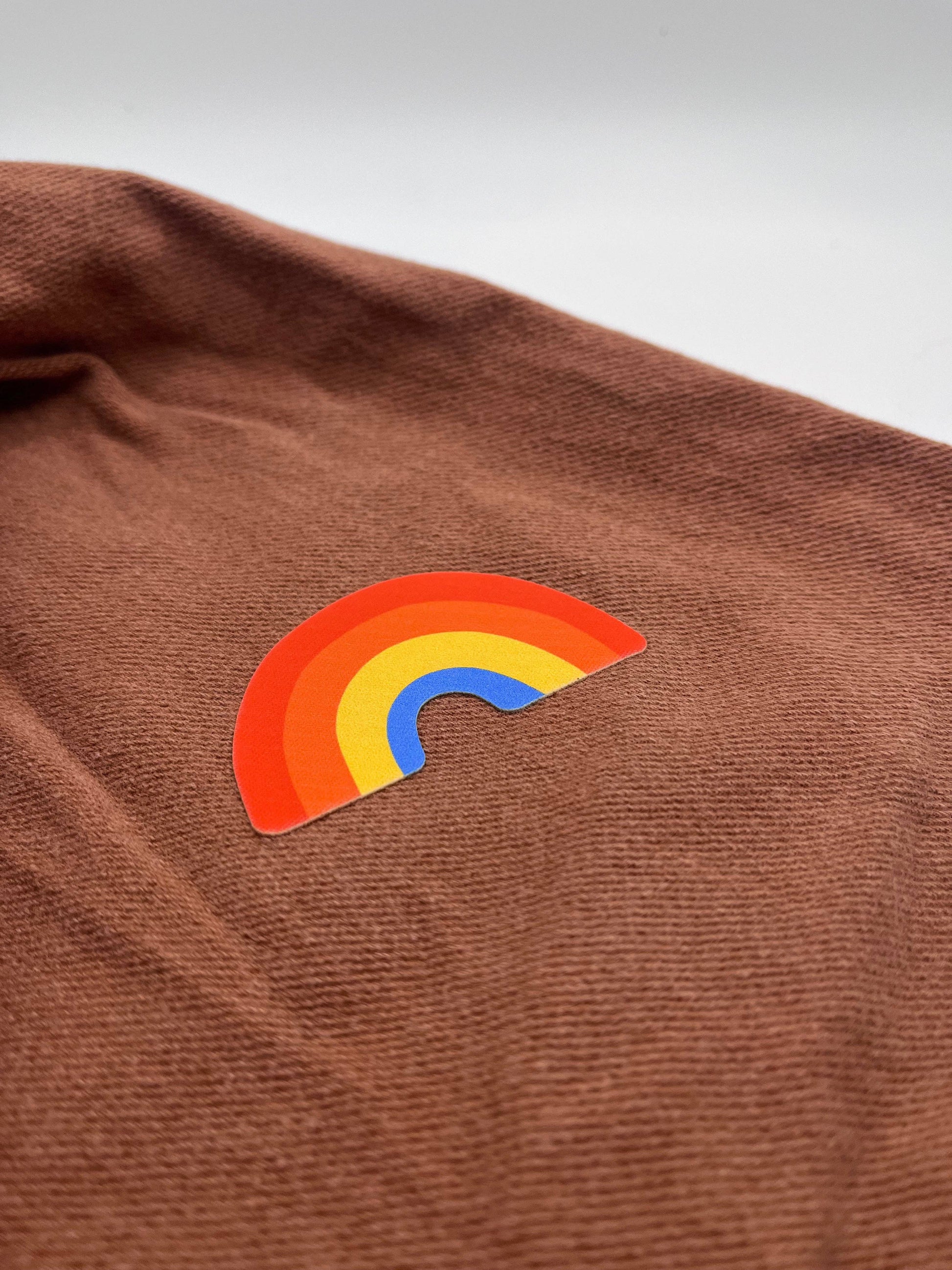 Brown fabric with a rainbow patch on a gray background