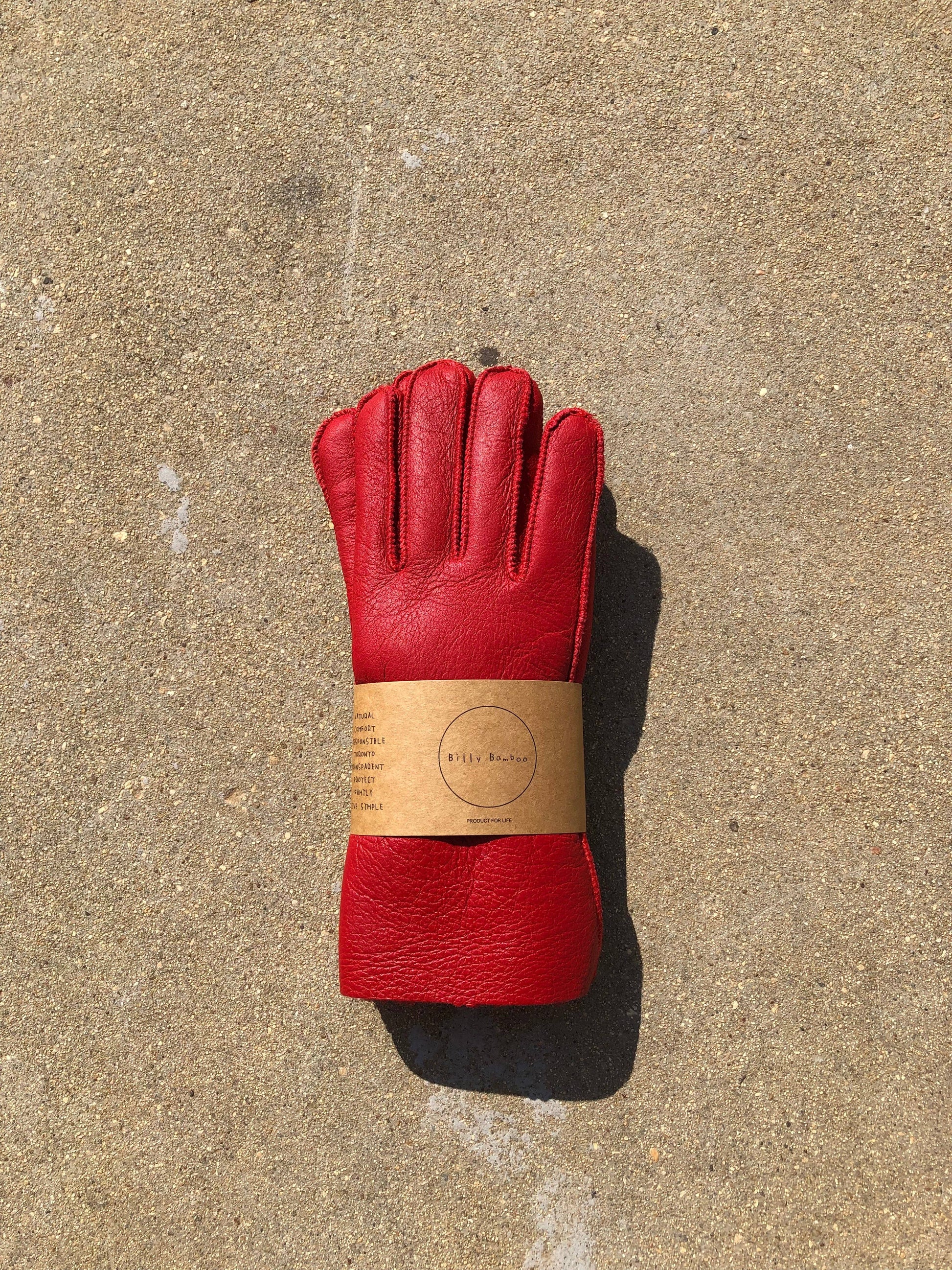 Red leather glove with a label on a concrete surface