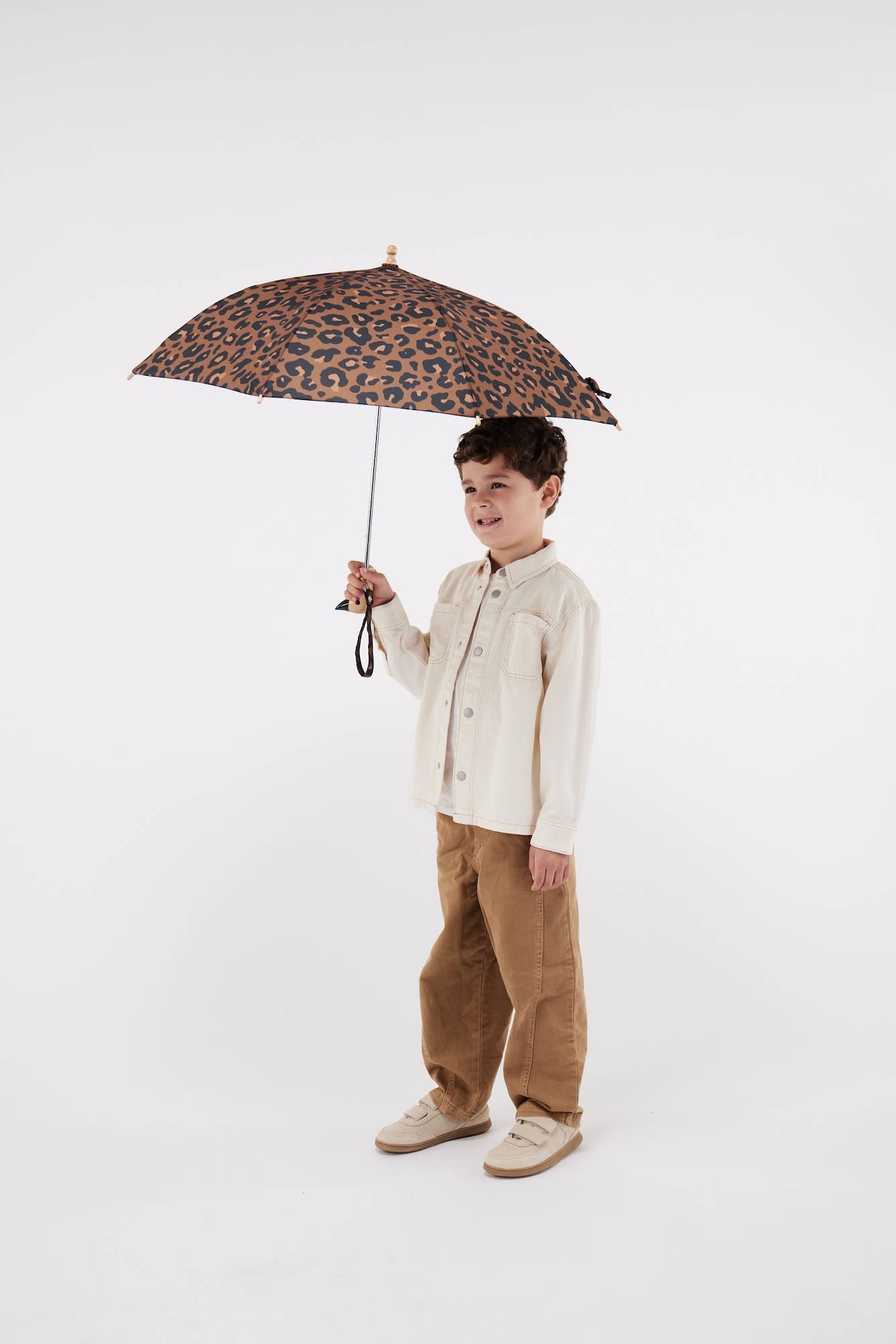 Child holding a leopard print umbrella on a white background