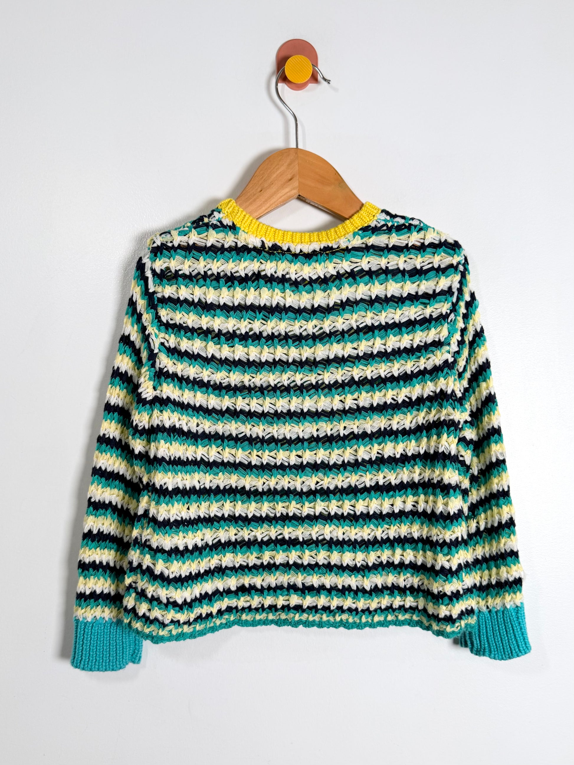 Striped sweater on a wooden hanger against a white background