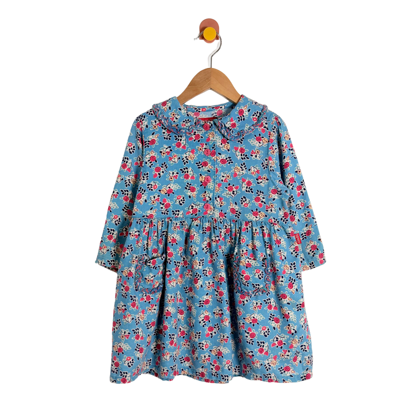 Children's floral dress on a hanger against a white background