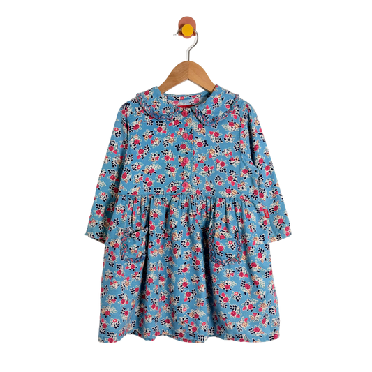 Children's floral dress on a hanger against a white background