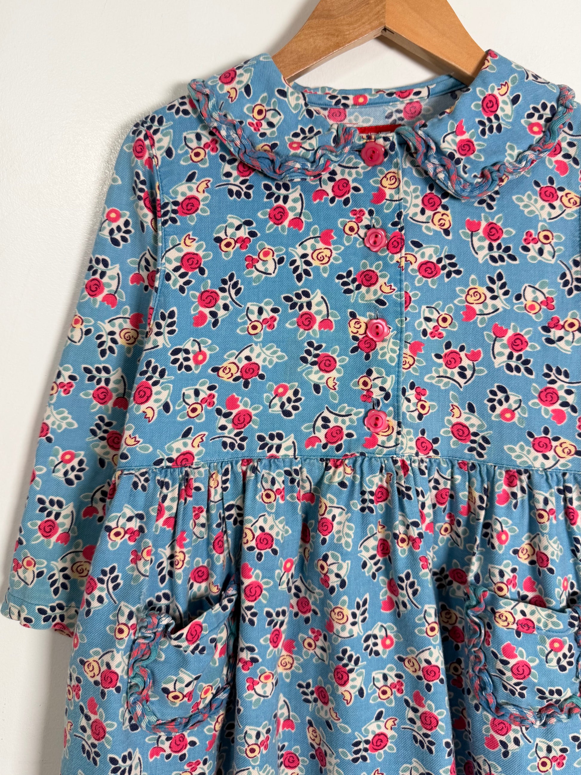 Floral dress on a hanger against a white background