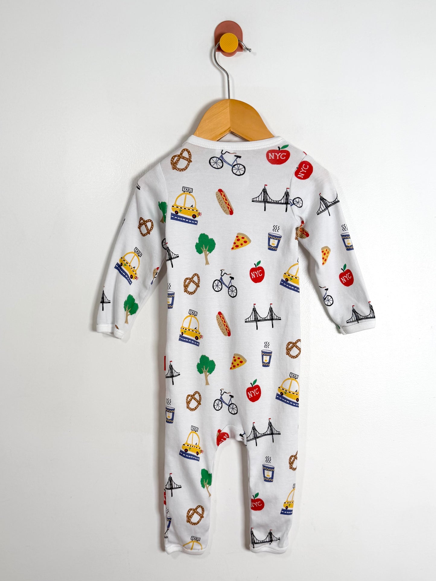 Baby onesie with colorful graphics on a hanger against a white background