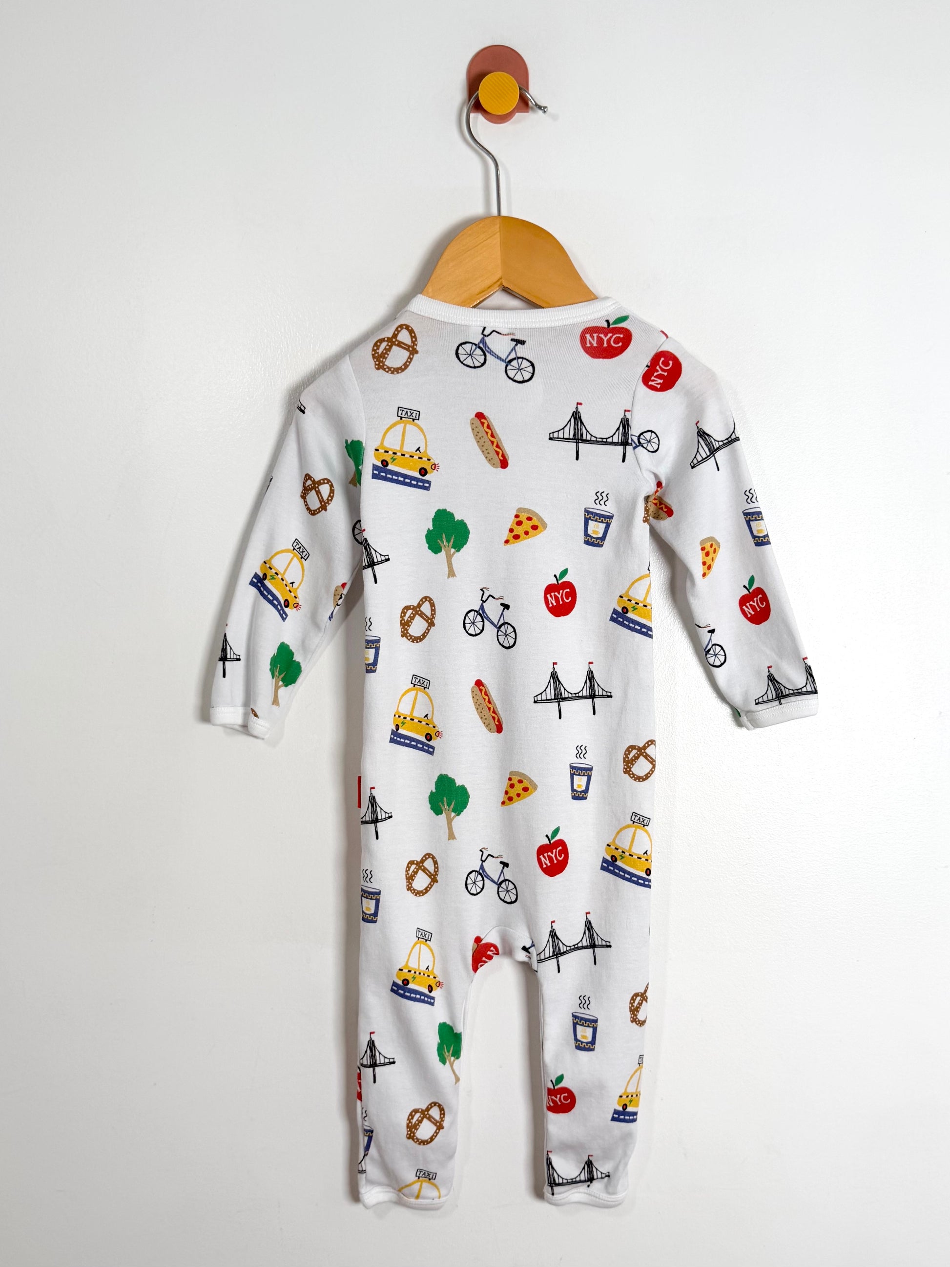 Baby onesie with colorful graphics on a hanger against a white background