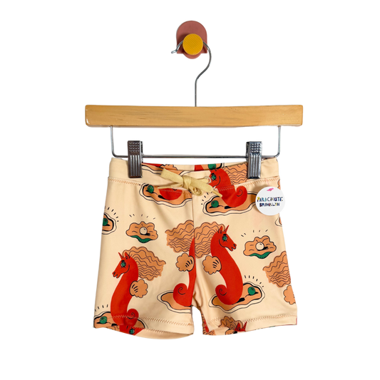 Children's shorts with a horse pattern on a hanger against a white background