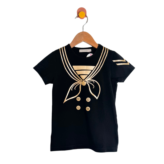 Black t-shirt with gold accents on a wooden hanger against a white background