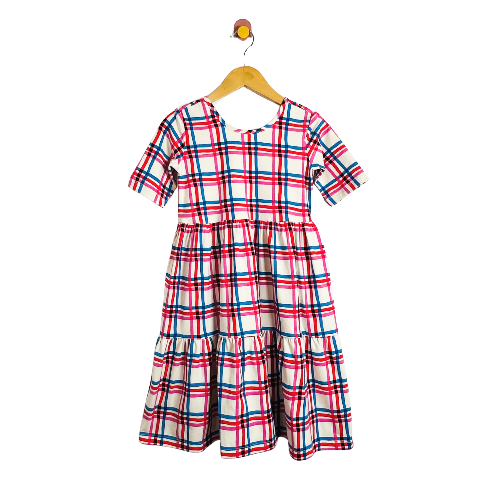 Plaid dress on a hanger against a white background