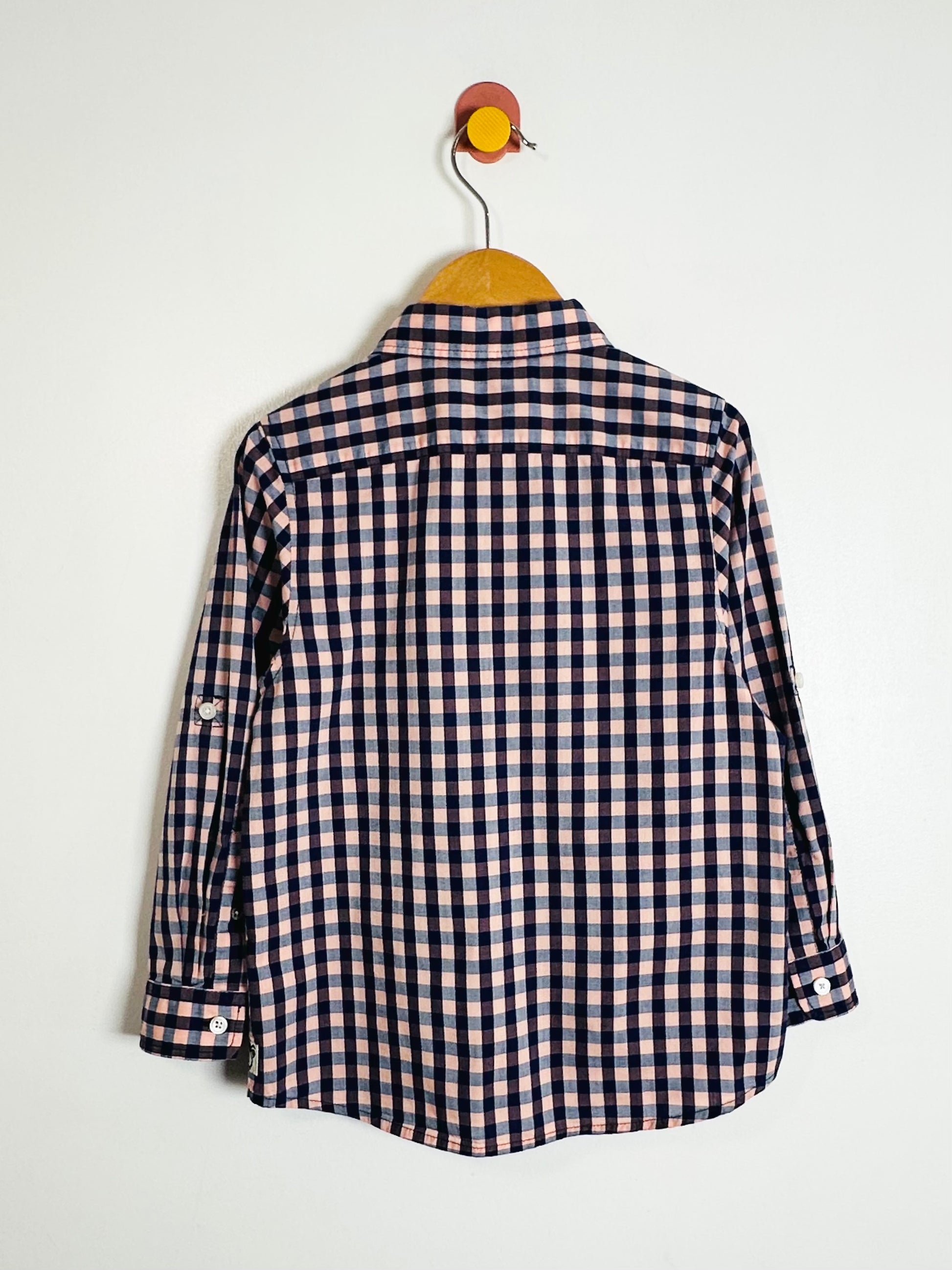 Checkered shirt on a hanger against a white background