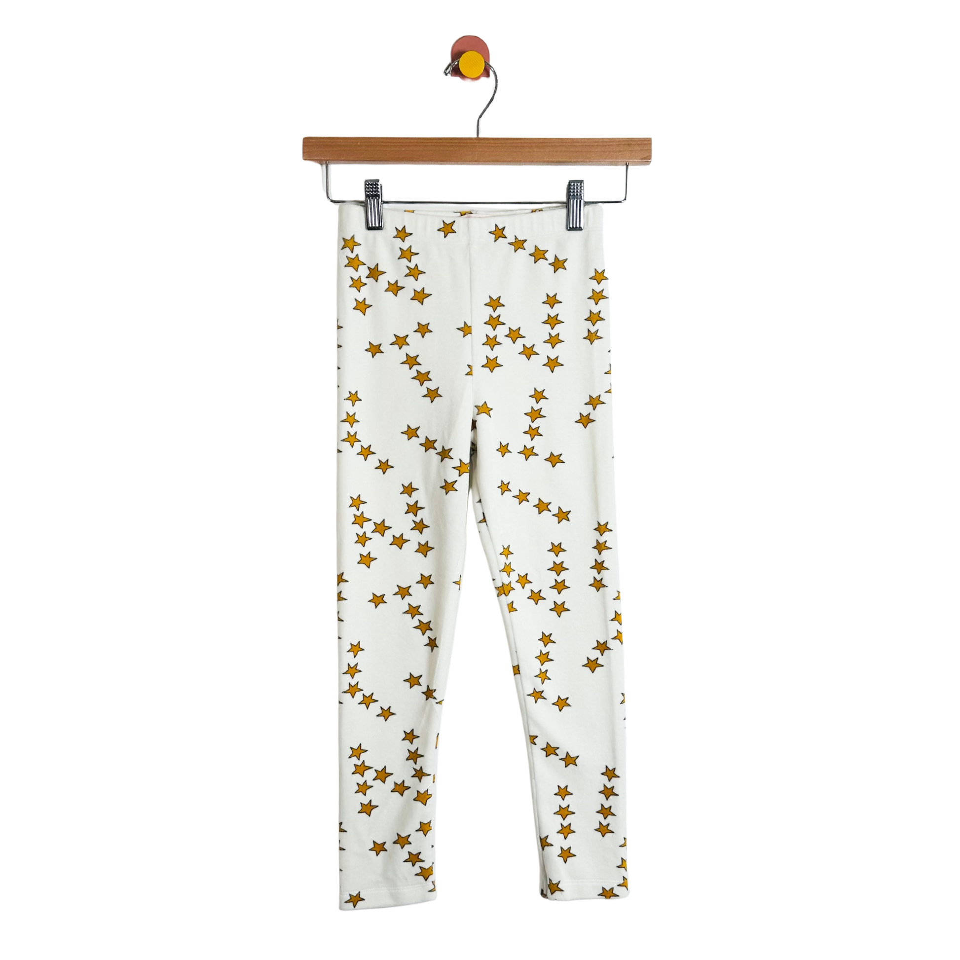 White pants with gold star pattern on a hanger against a white background