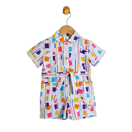 Colorful geometric patterned outfit on a hanger against a white background