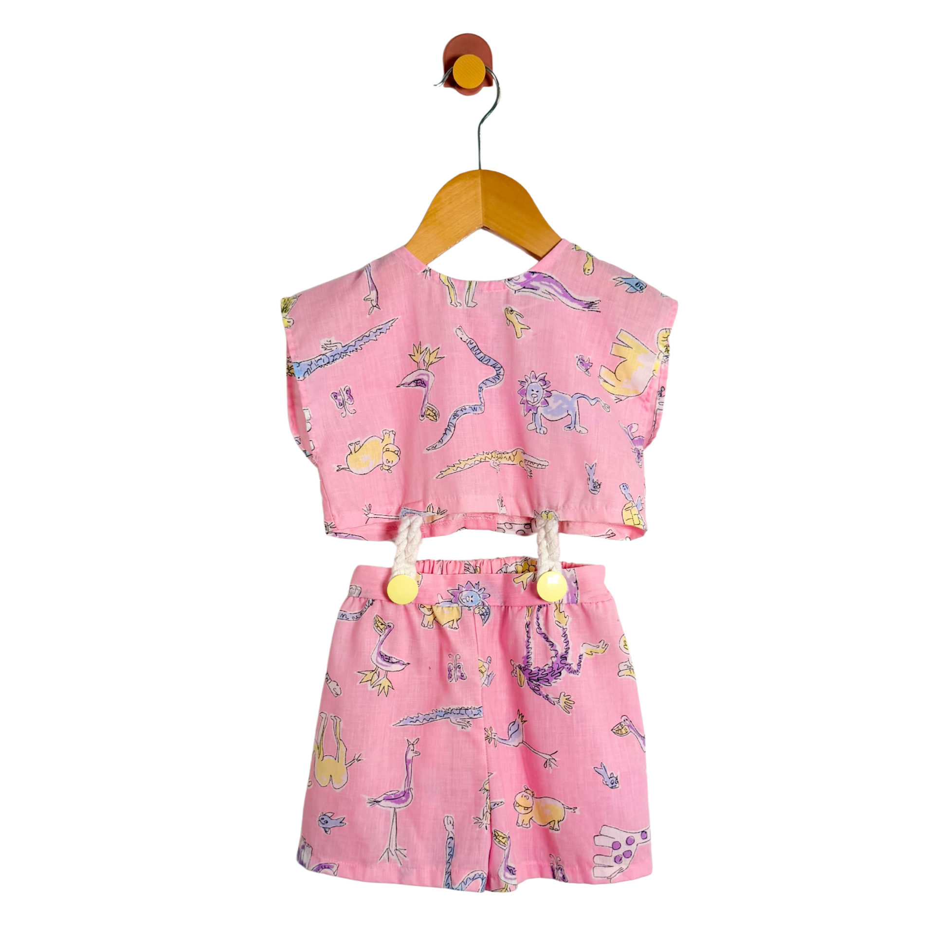 Pink children's outfit with cartoon designs on a white background