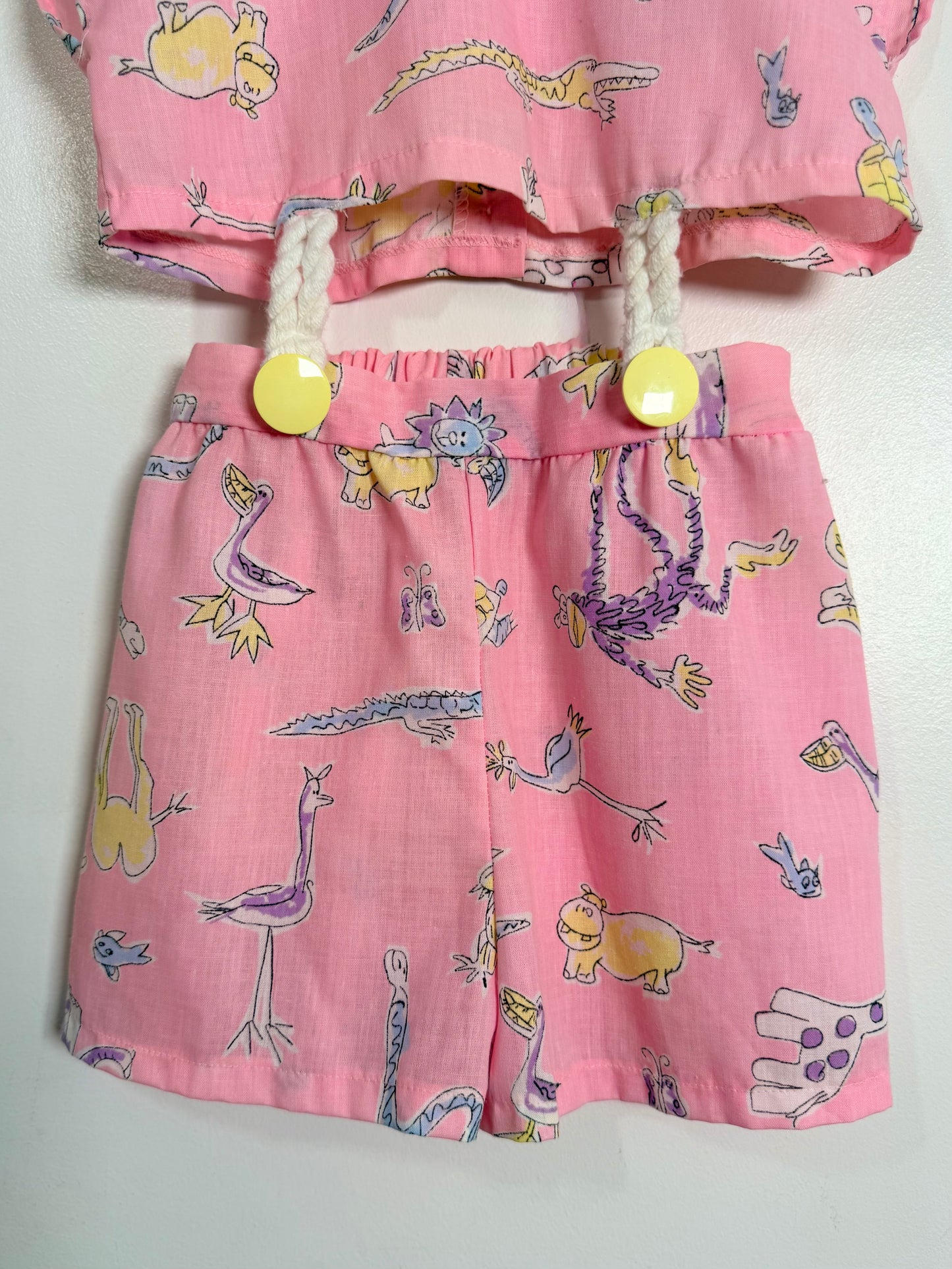 Children's pink outfit with animal print top and shorts on a white background