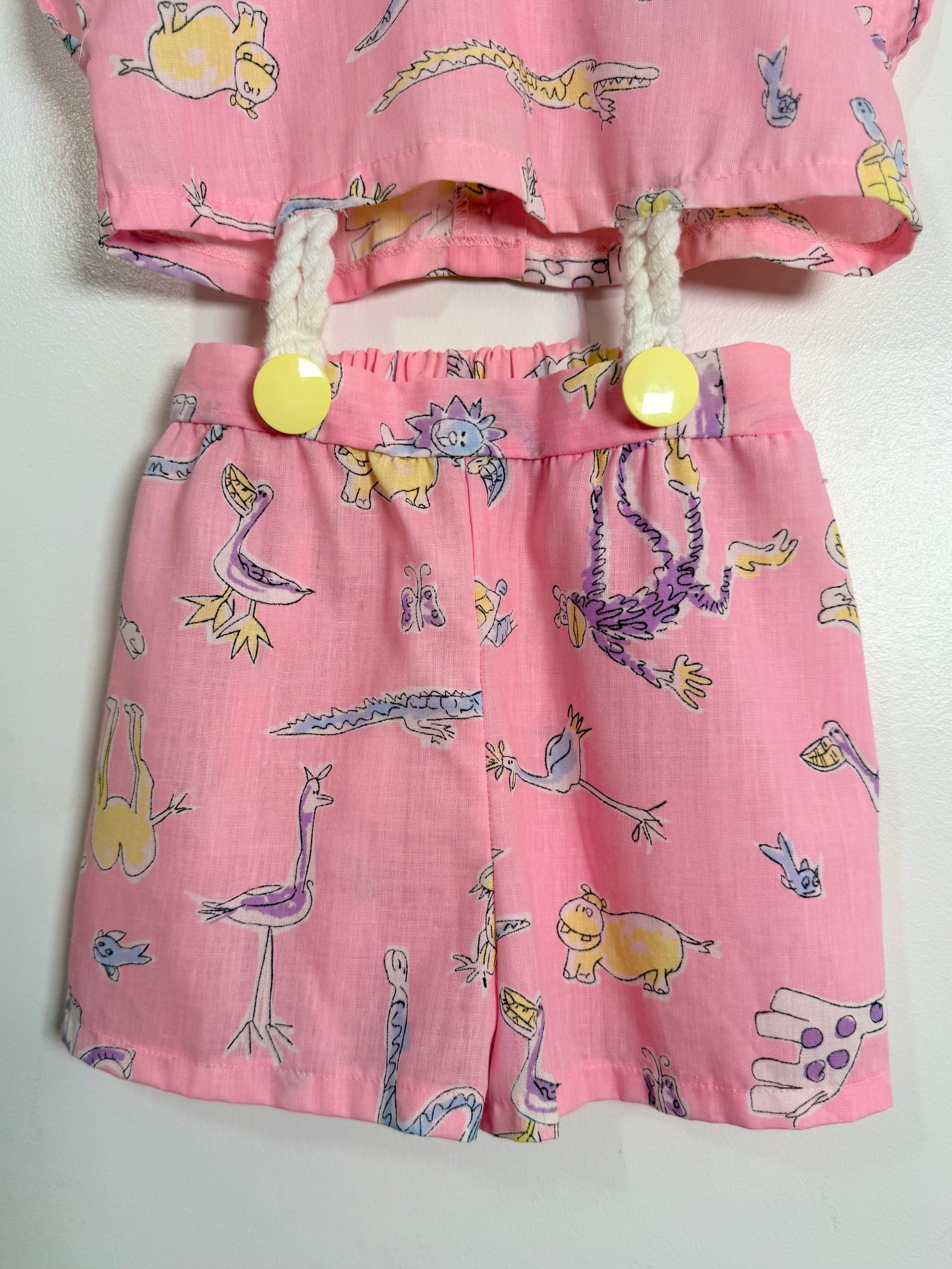 Children's pink outfit with animal print top and shorts on a white background