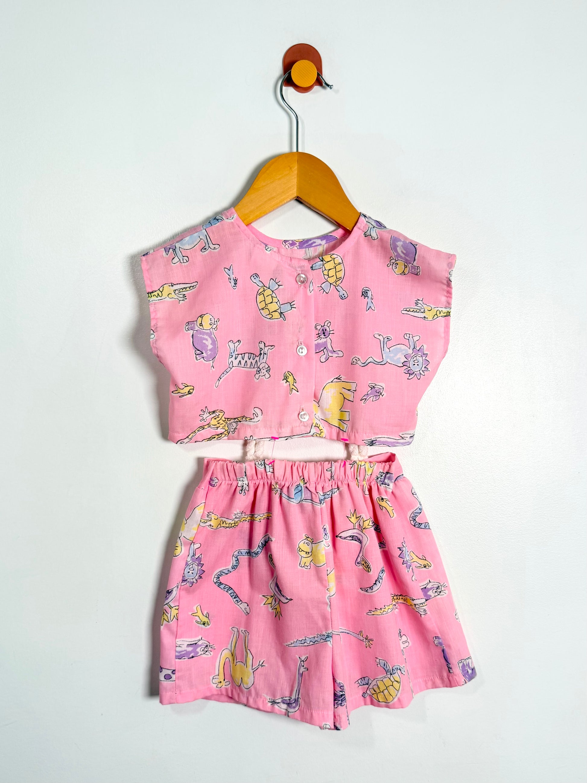 Pink children's outfit with cartoon print on a white background