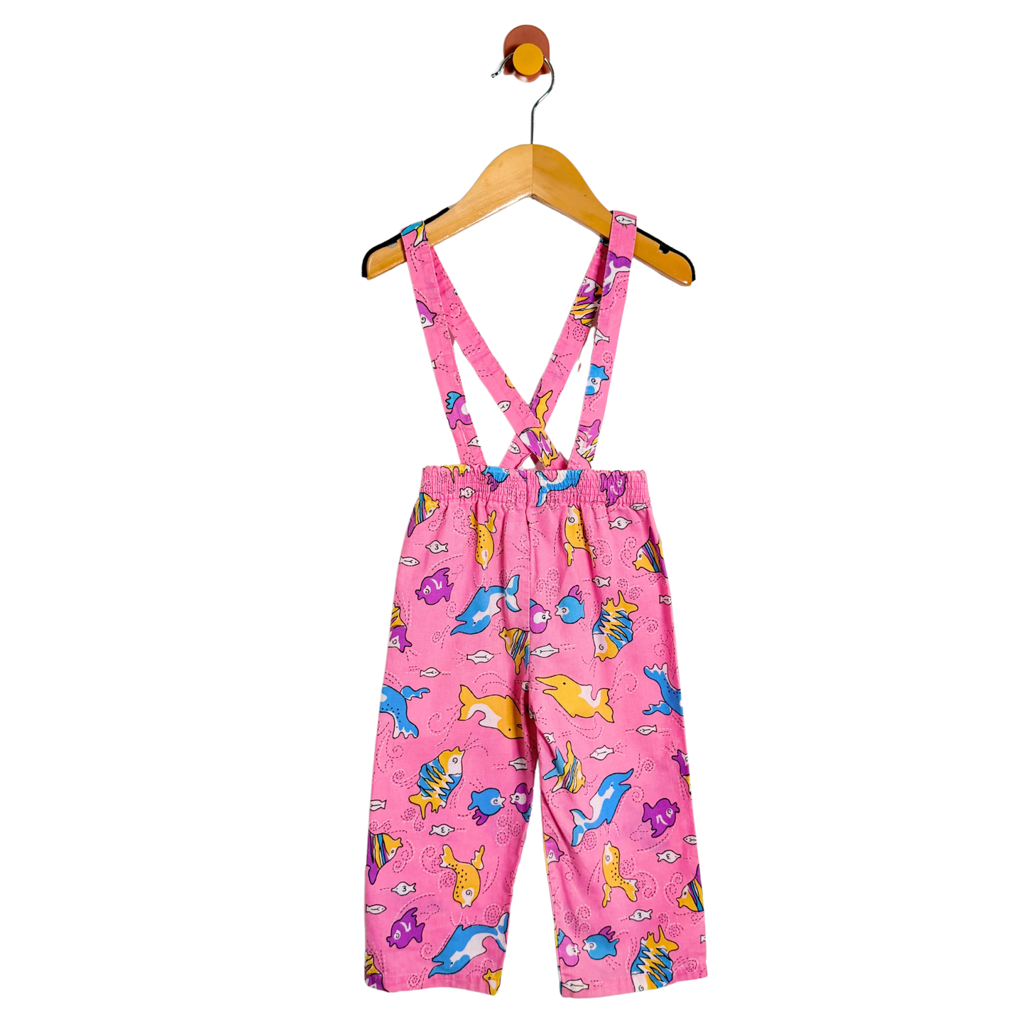 Pink children's overalls with animal pattern on a hanger against a white background