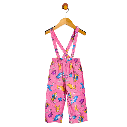 Pink children's overalls with animal pattern on a hanger against a white background