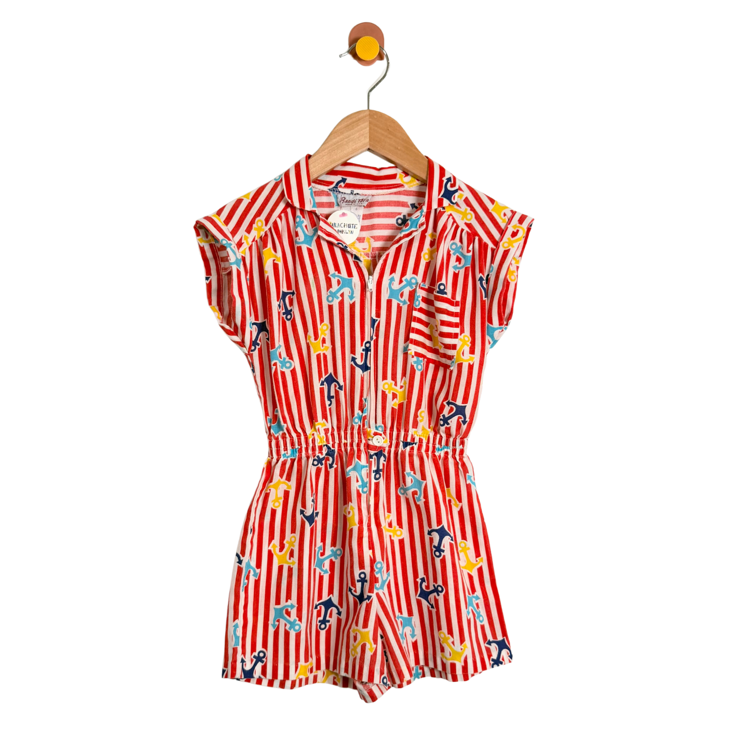 Red and white striped romper with anchor pattern on a hanger against a white background
