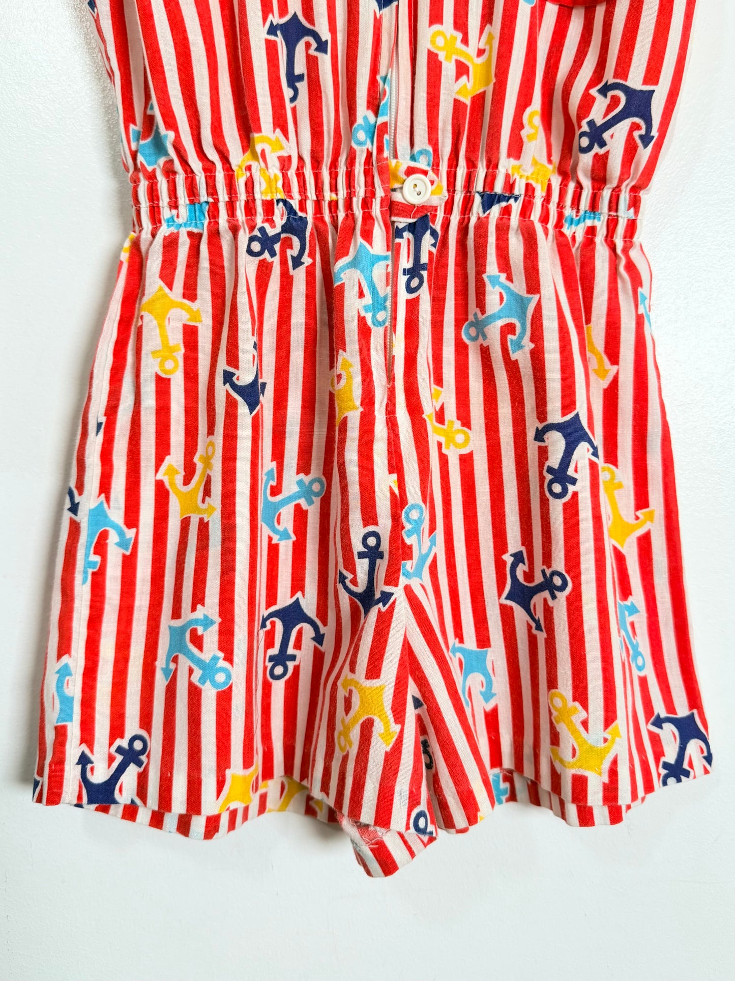 Red and white striped romper with colorful anchor pattern on a white background