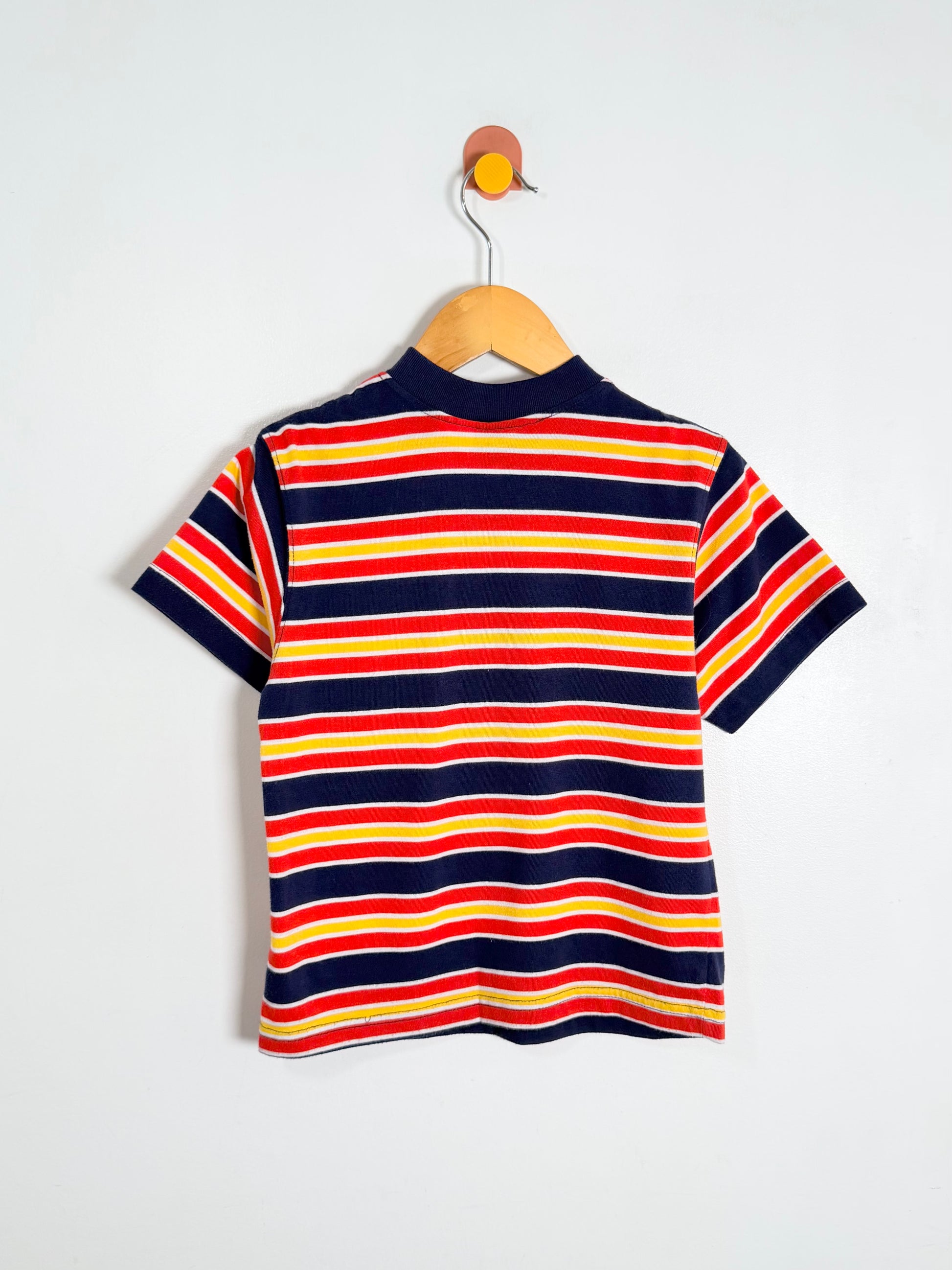 Striped polo shirt on a hanger against a white background