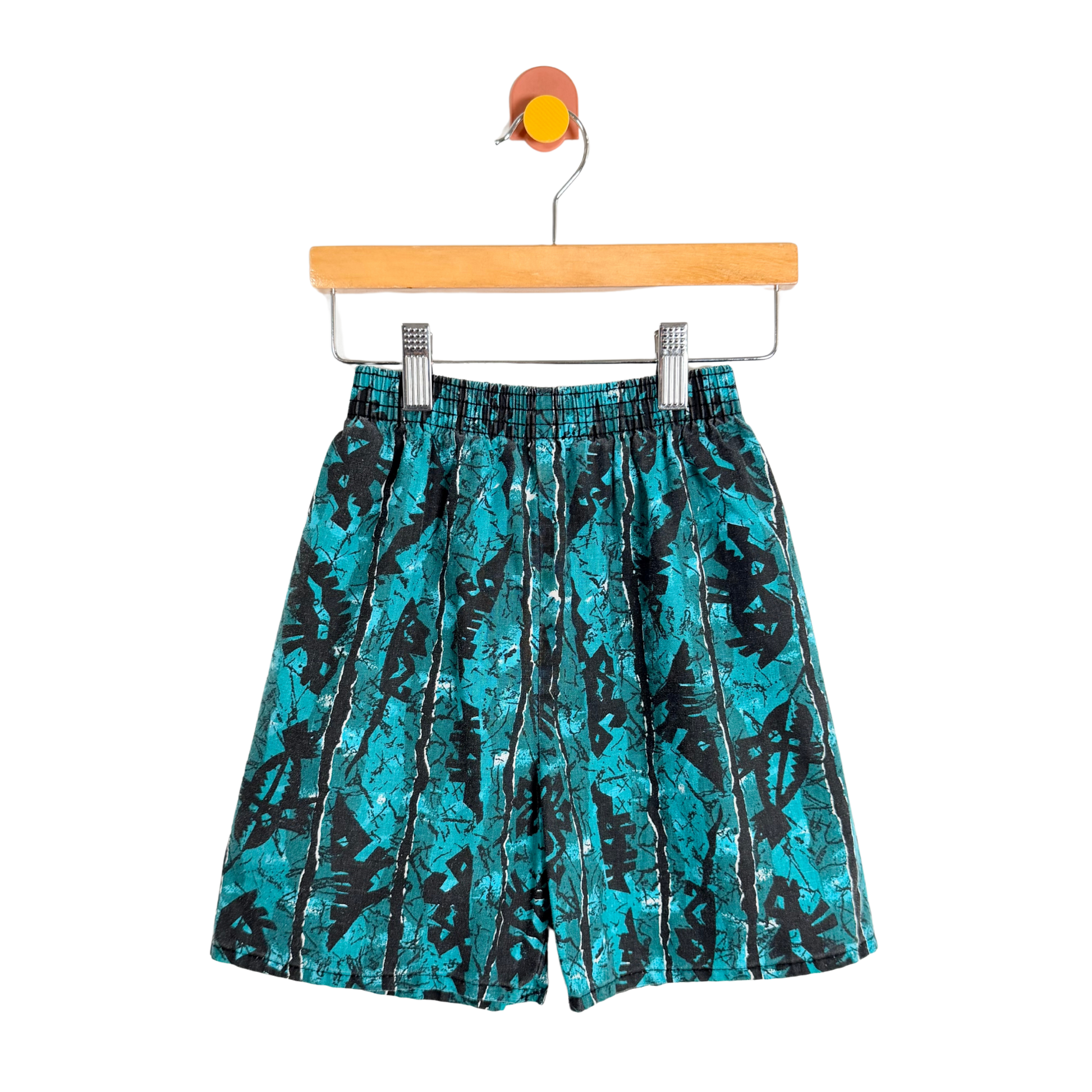 Teal and black patterned shorts on a hanger against a white background