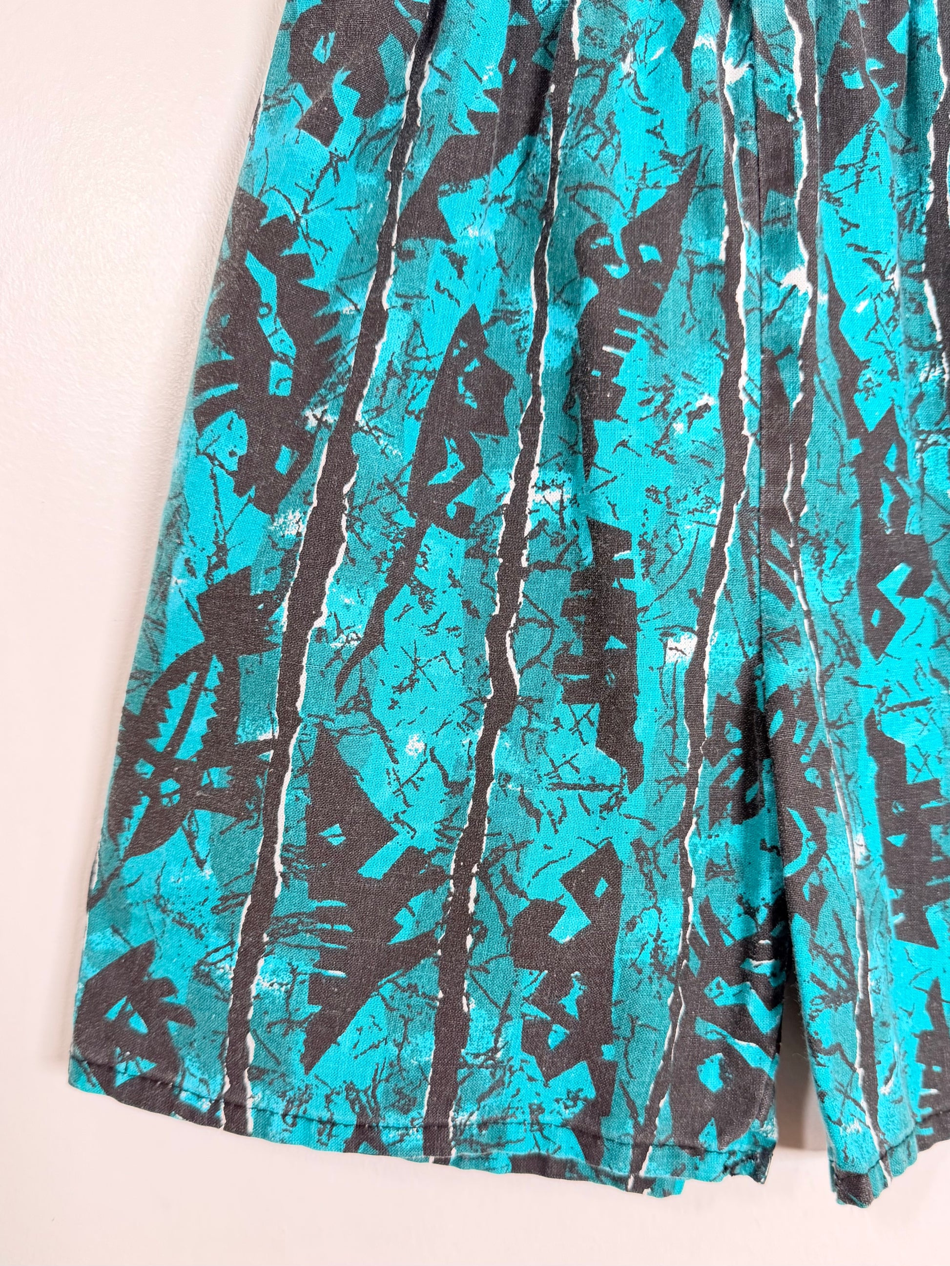 Teal and black patterned fabric on a beige background