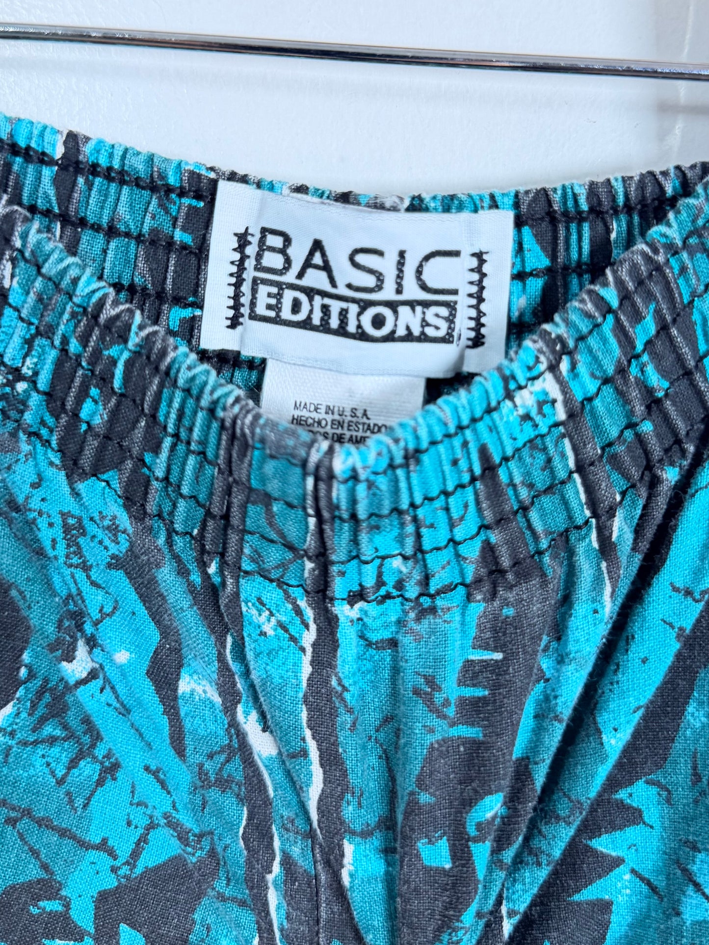 Close-up of patterned shorts with a 'Basic Editions' label.