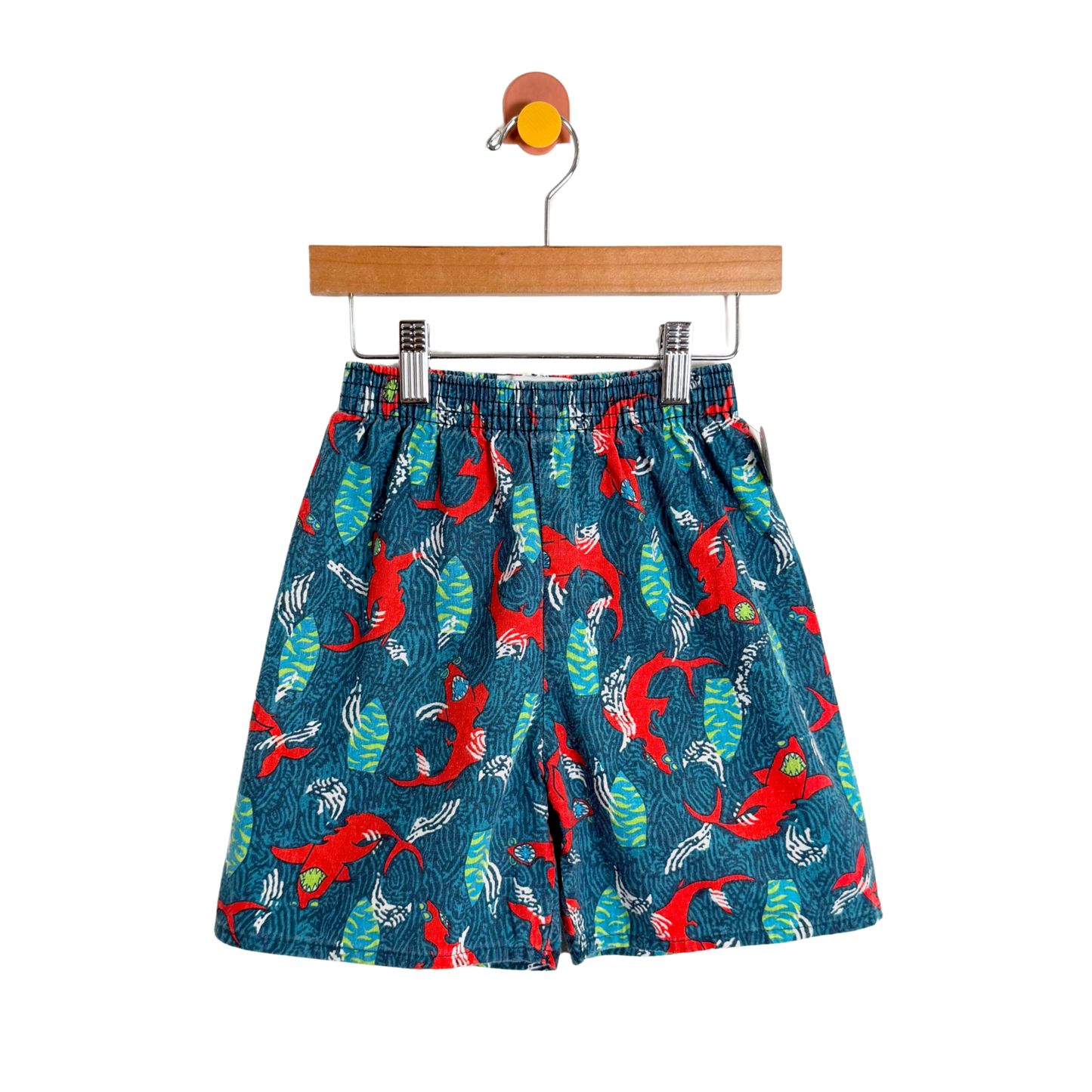 Children's shorts with a red and green pattern on a white background
