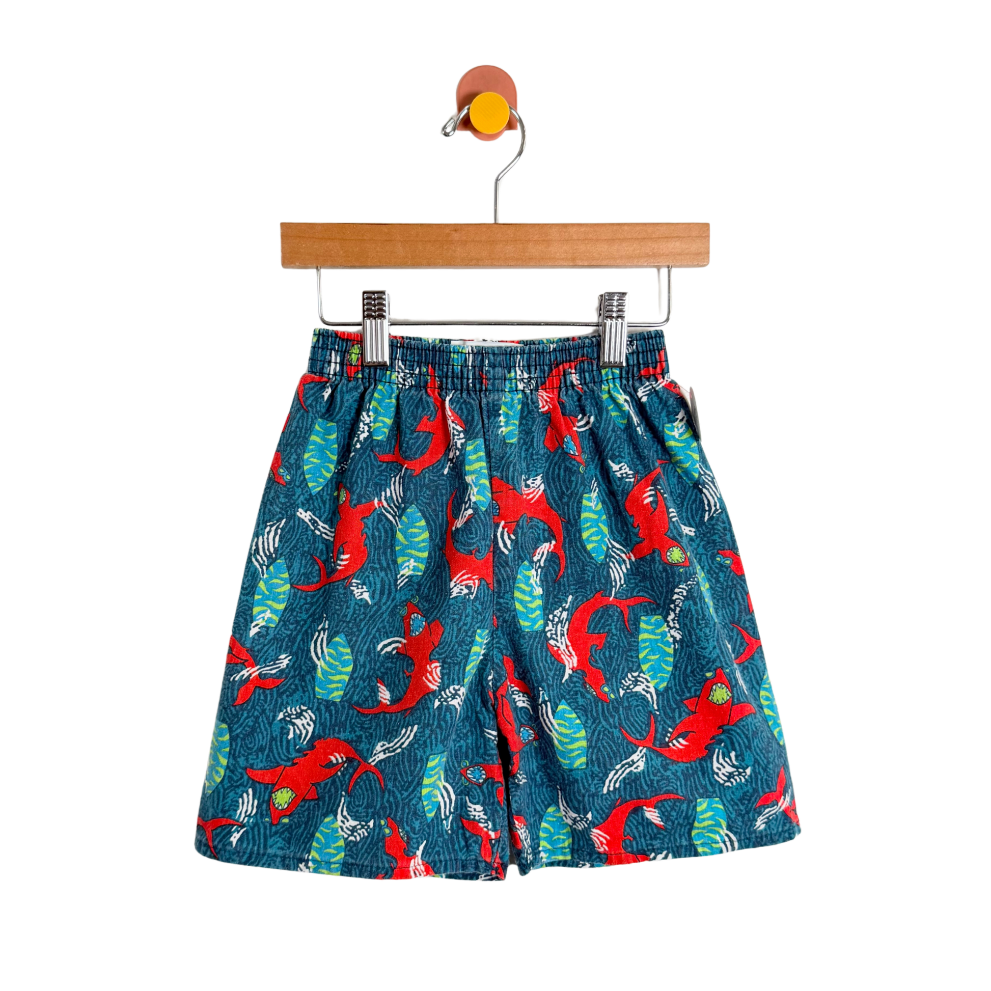 Children's shorts with a red and green pattern on a white background