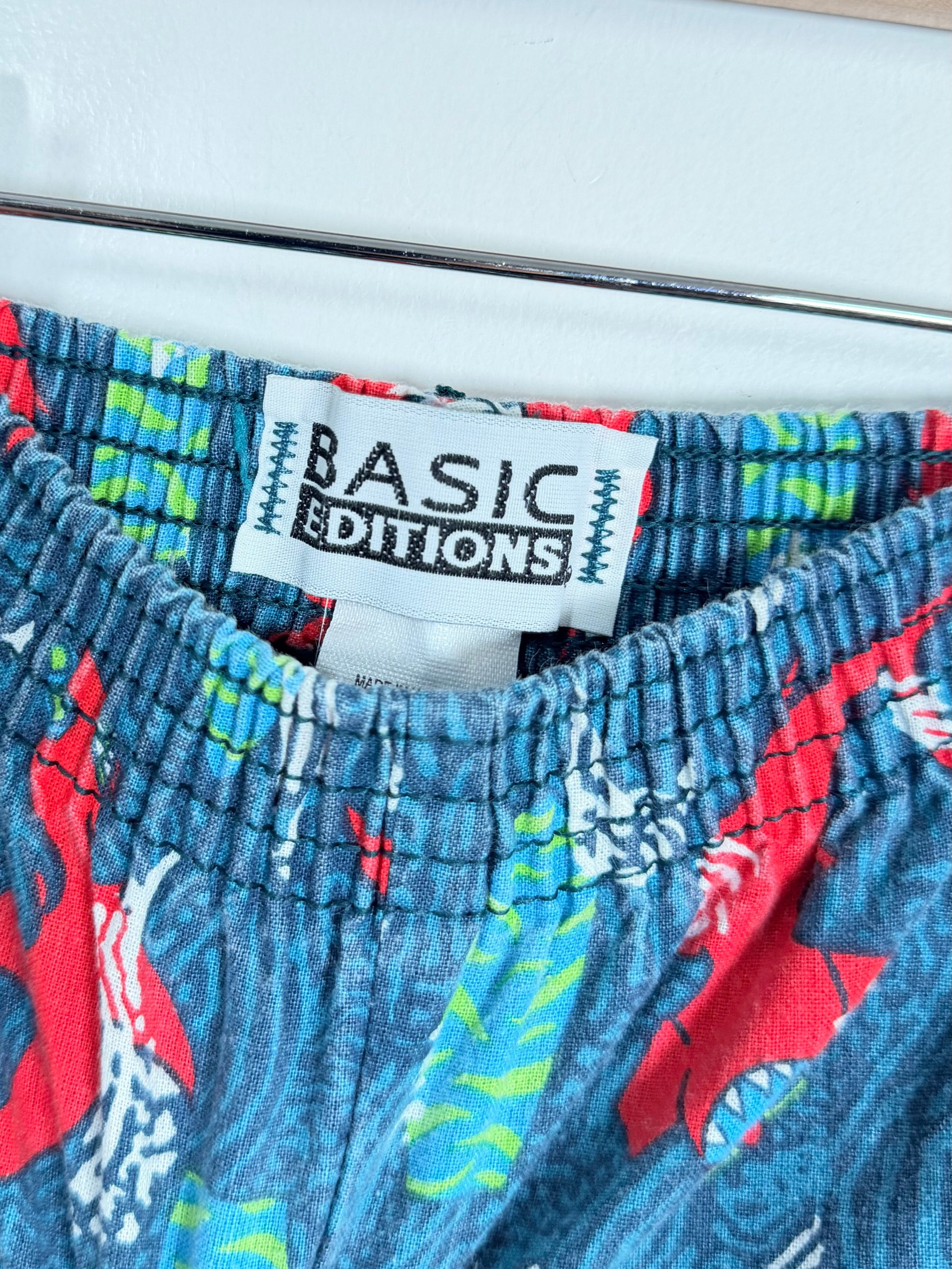 Close-up of colorful shorts with a 'Basic Editions' label.