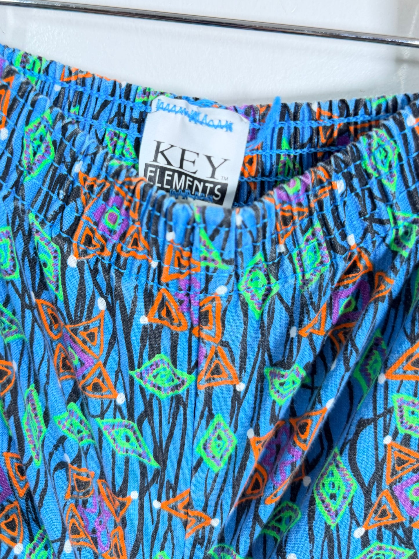Colorful patterned shorts with a 'Key Elements' label on a white background