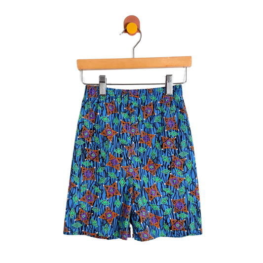 Colorful patterned shorts on a hanger against a white background