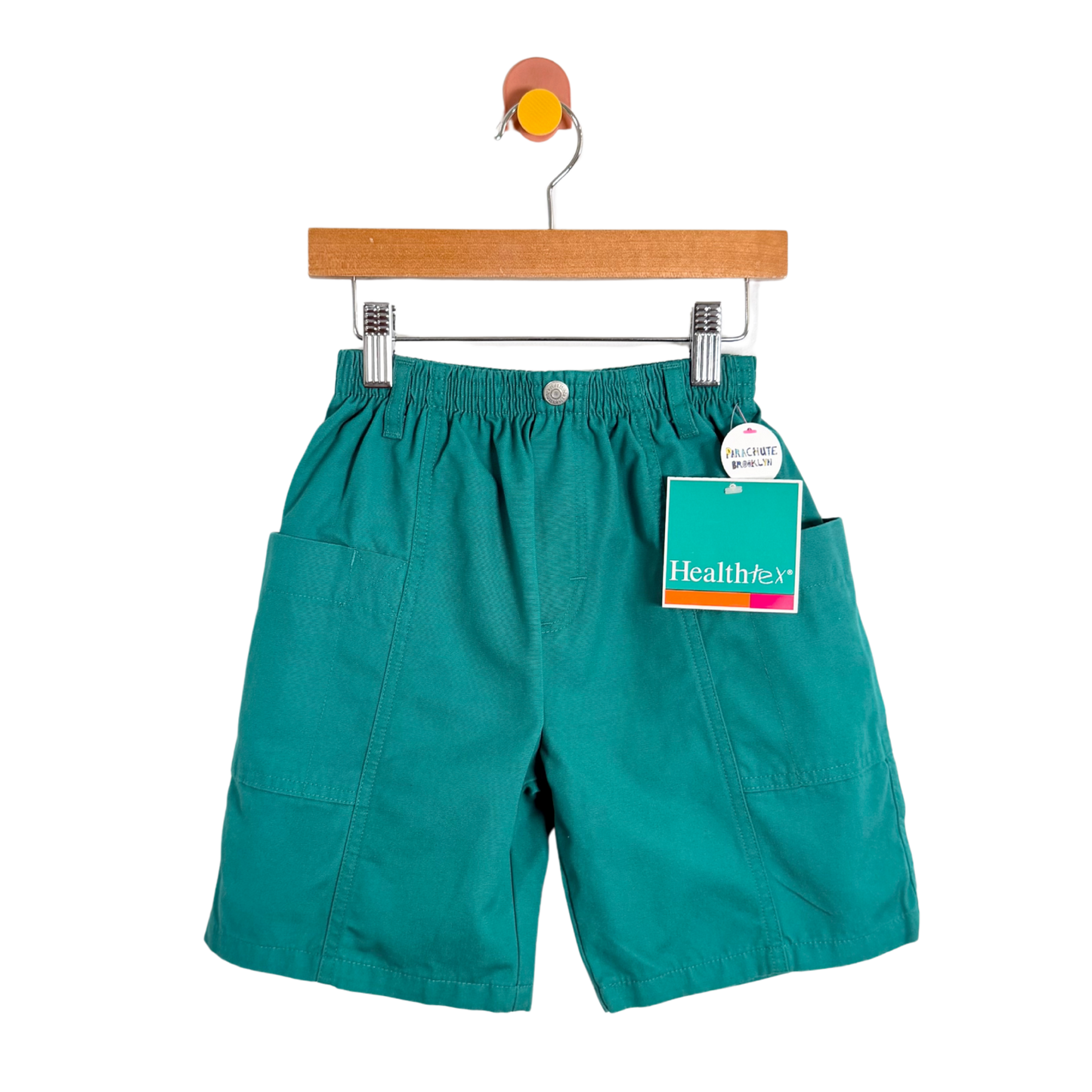 Teal shorts on a hanger with a tag on a white background